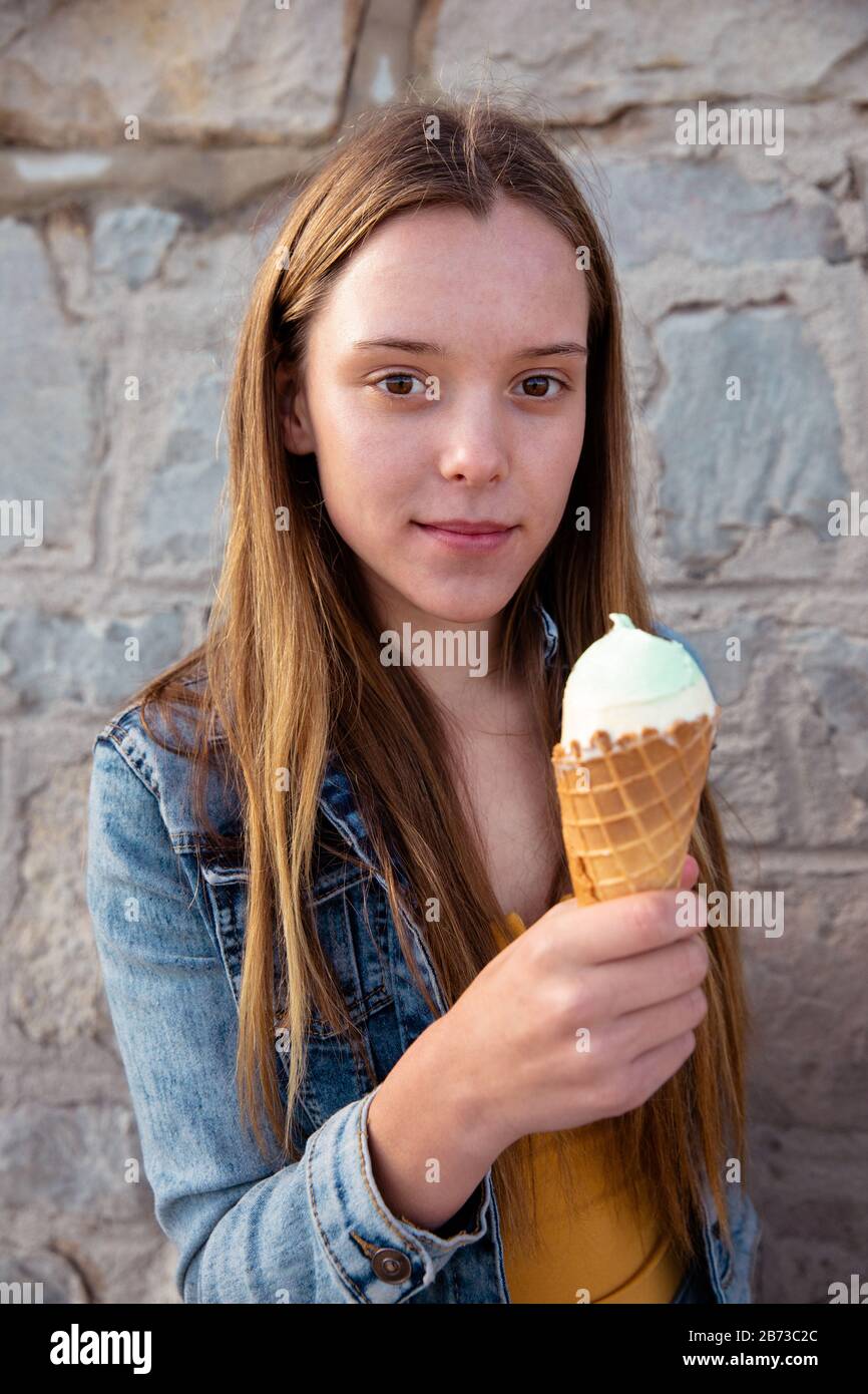 Portrait eines Mädchens, das Eiscreme isst und die Kamera betrachtet Stockfoto
