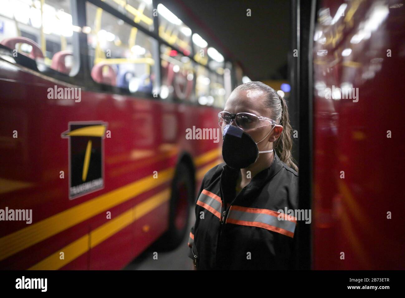 (200313) -- BOGOTA, 13. März 2020 (Xinhua) -- Eine Mitarbeiterin trägt eine Gesichtsmaske, während sie einen Bus in Bogota, der Hauptstadt Kolumbiens, am 11. März 2020 reinigt. Der kolumbianische Präsident Ivan Duque hat einen landesweiten Gesundheitsnotstand ausgerufen, der jegliche Aktivitäten von mehr als 500 Menschen untersagt, und infolgedessen wurde die diesjährige Internationale Buchmesse von Bogota auf einen späteren Zeitpunkt verschoben. (Xinhua/Jhon Paz) Stockfoto