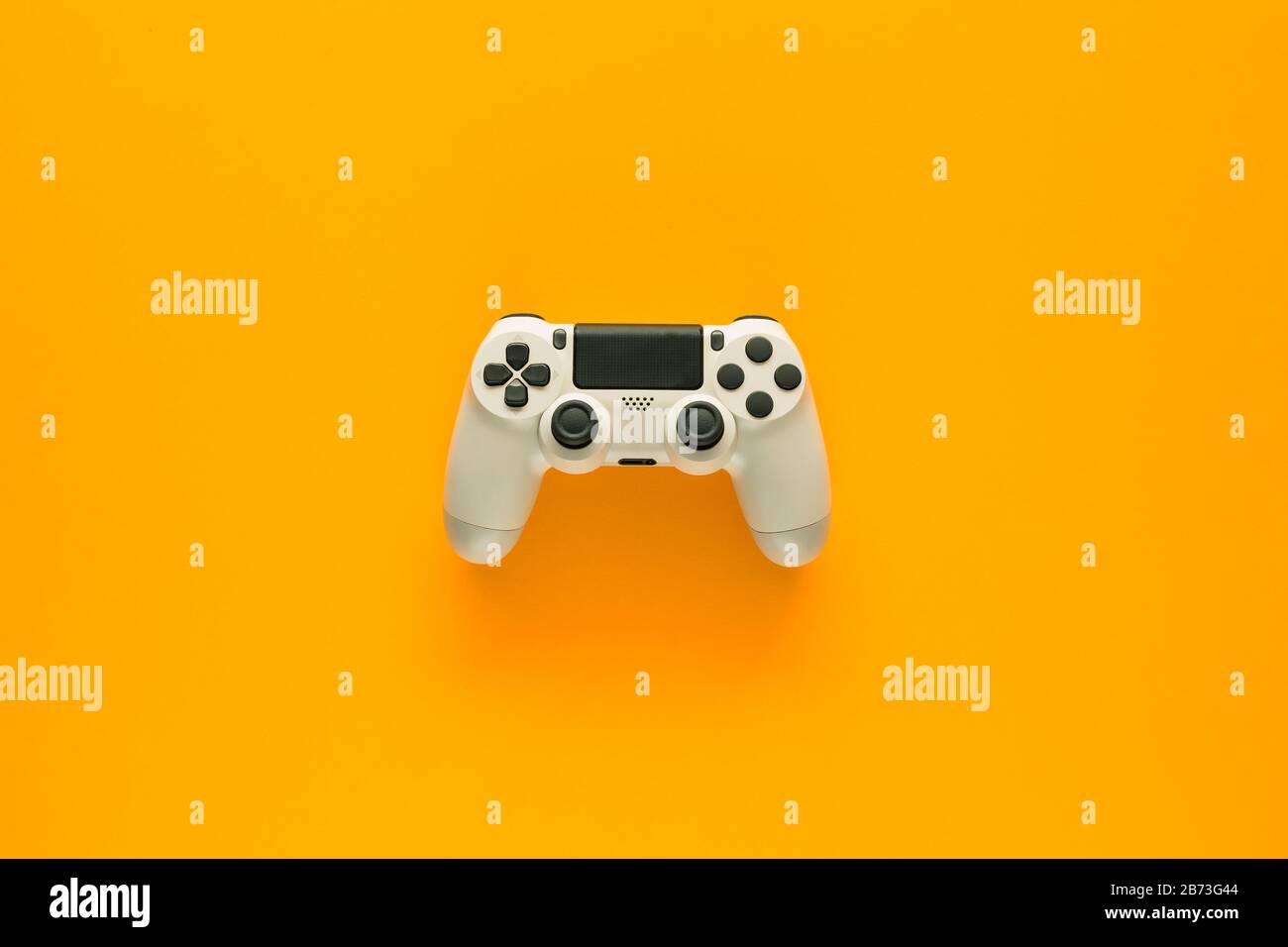 Stockfoto eines weißen Gamepads inmitten eines gelben Hintergrunds Stockfoto