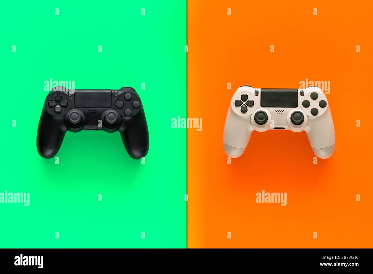 Stock-Foto von zwei Gamepads in der Mitte von zwei farbigen Hintergründen Stockfoto