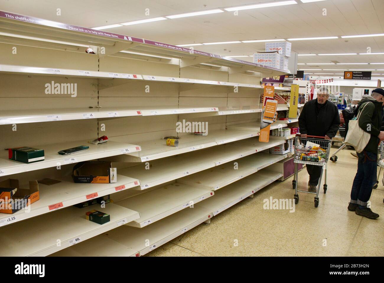 sainsburys haringey london; Käufer und leere Regale; toilettenrollen, Nudelwaren, die durch den Panikkauf des öffentlichen UK england ausverkauft wurden Stockfoto