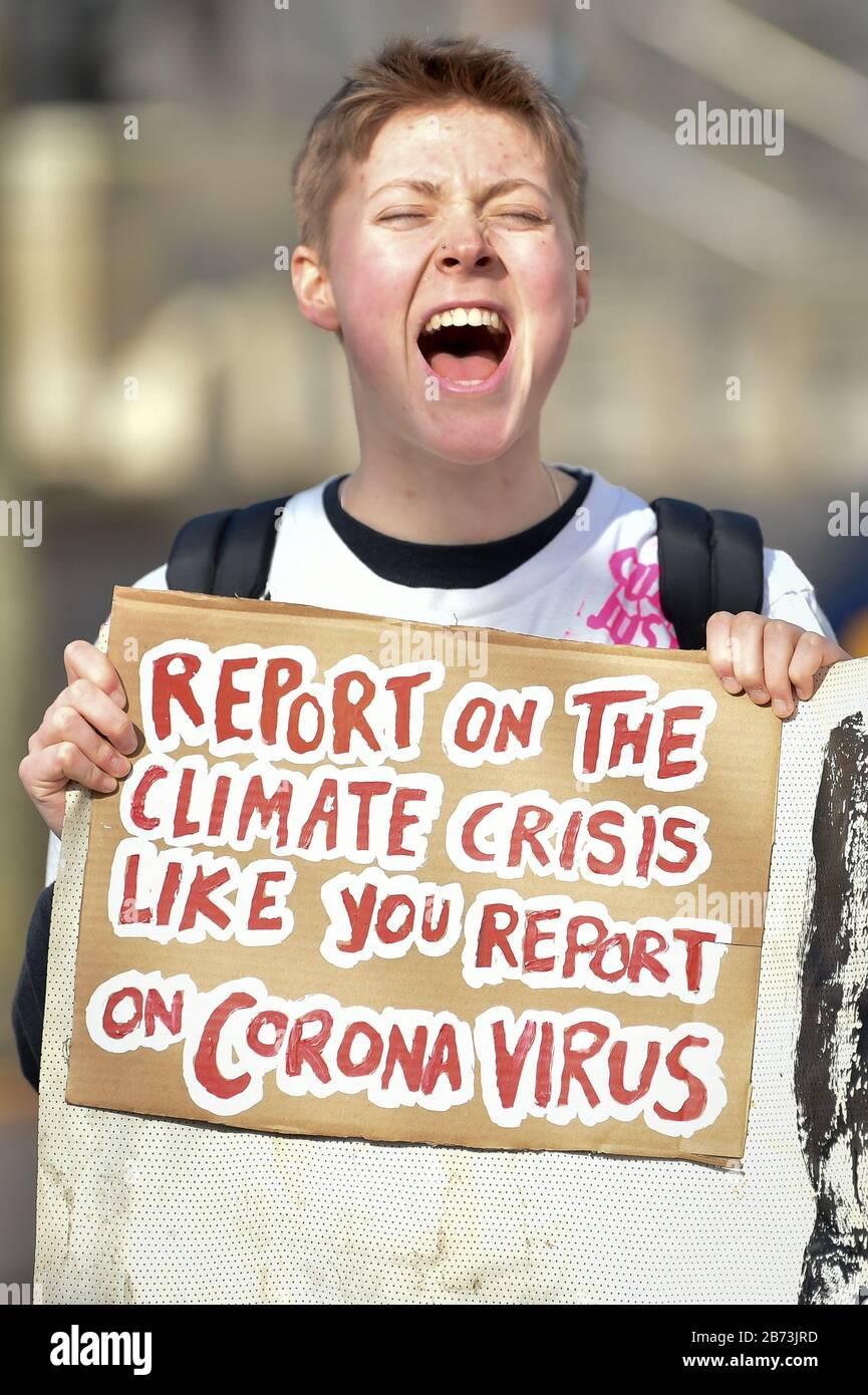 Ein Protestler hält ein Schild, das Coronavirus während eines Schulklimastreiks von Cardiff City Hall zur Nationalversammlung für Wales verweist. Stockfoto