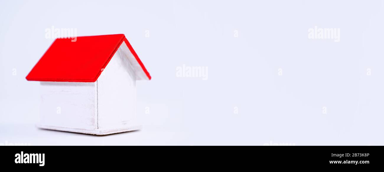 Finanzklage - Piggy Bank, wunderschönes rot-weißes Holzhausmodell auf weißem Hintergrund, spart Geld beim Kauf von Versicherungen, Nahaufnahme, Kopierplatz. Stockfoto
