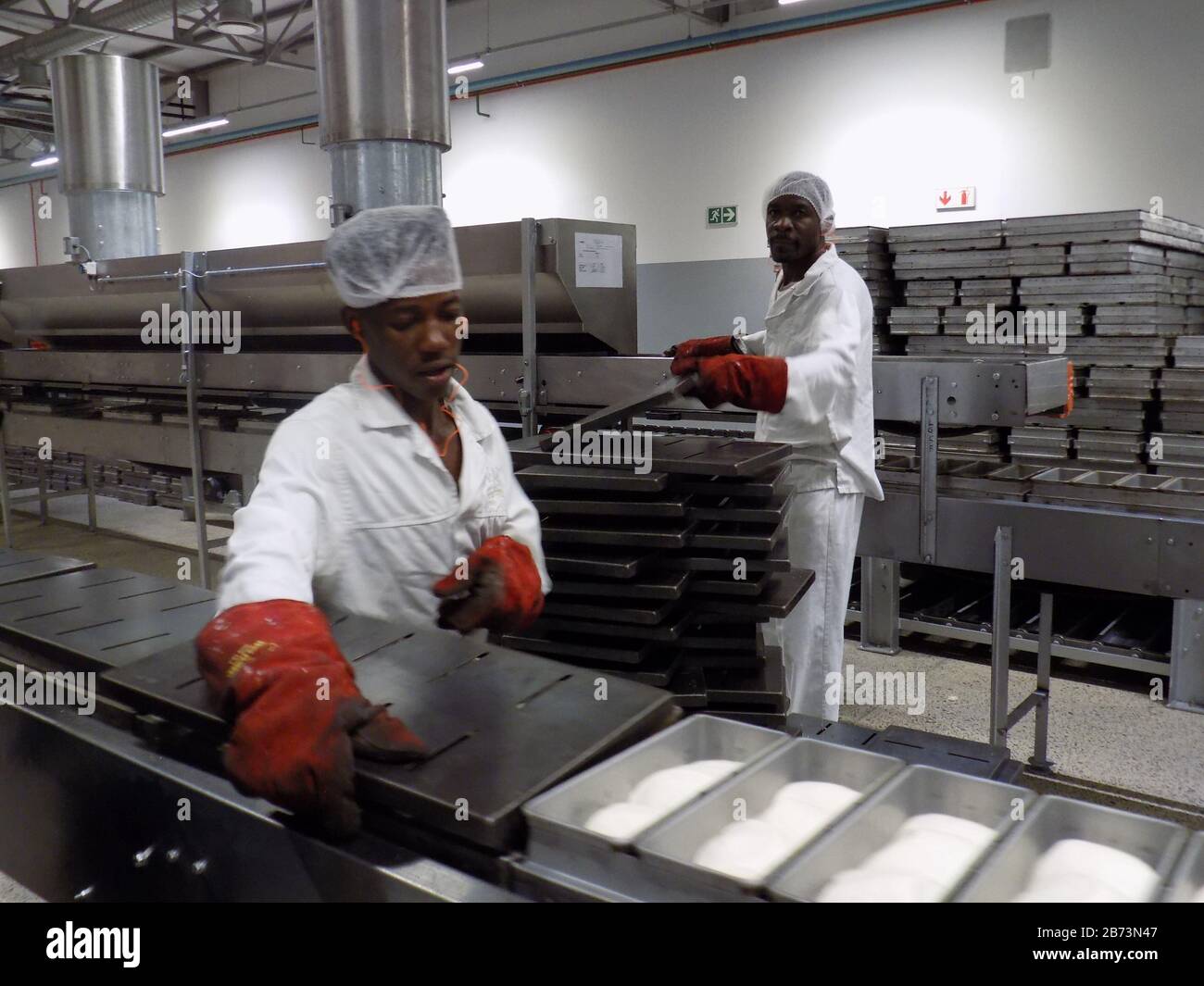 (200313) -- WINDHOEK, 13. März 2020 (Xinhua) -- Menschen arbeiten in einer Brotfabrik in Windhoek, Namibia, 12. März 2020. Der Minister für Industrialisierung, Handel und KMU-Entwicklung, Tjekero Tweya, hat am Donnerstag die erste moderne Brotfabrik des Landes mit einem Wert von rund 135 Millionen Namibia-Dollar (ca. 8,4 Millionen US-Dollar) eingeweiht. Das Fabriksystem läuft wie ein Förderband durch den gesamten Prozess des Mischen, Fermentierens, Backens und Verpackens. (Foto von Musa C Kaseke/Xinhua) Stockfoto