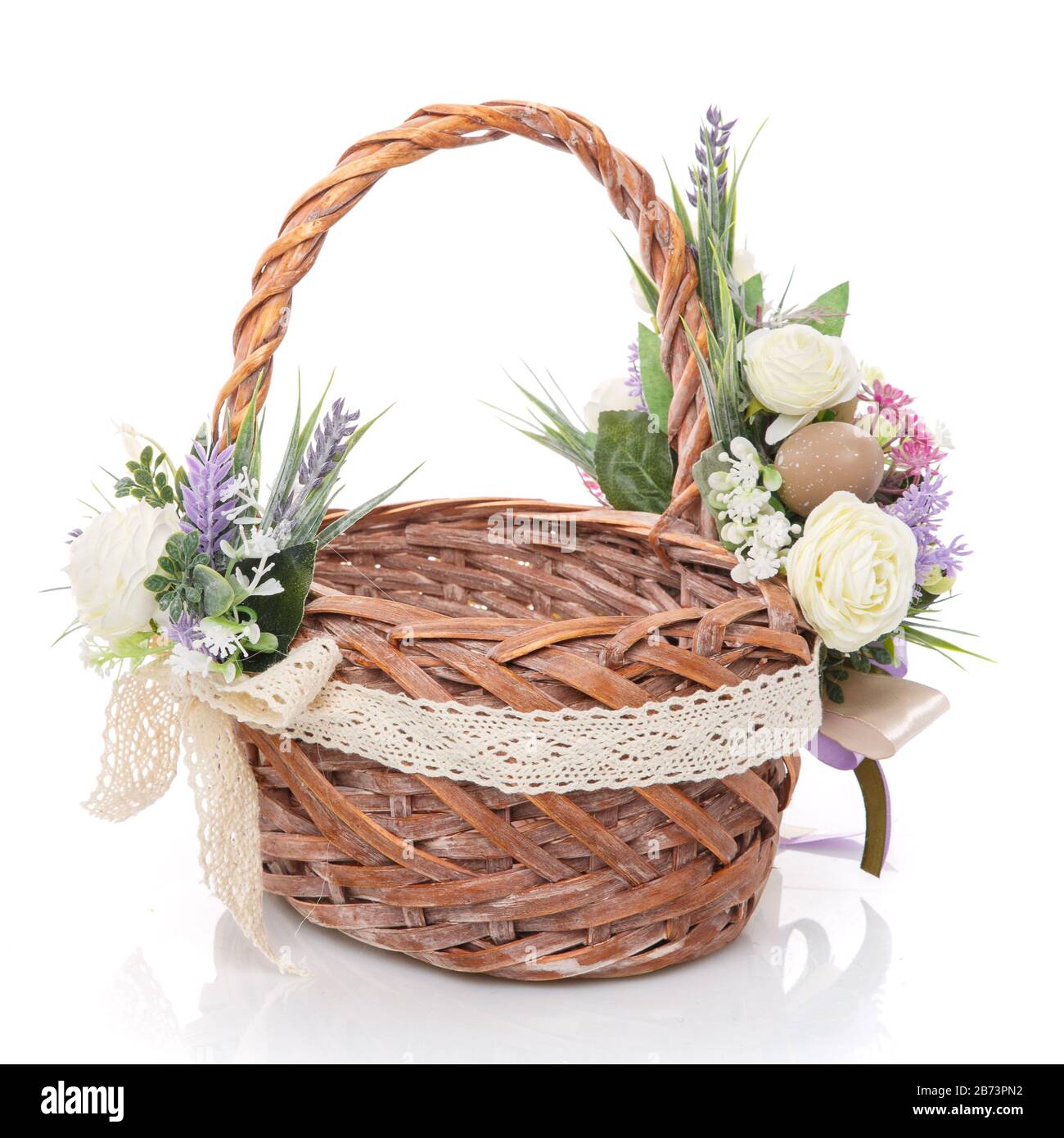 Schöner großer Weidenkorb mit zarten Blüten, Lavendel, Grün und Netz.  Dekoriert in rustikalem Stil auf weißem Hintergrund Stockfotografie - Alamy