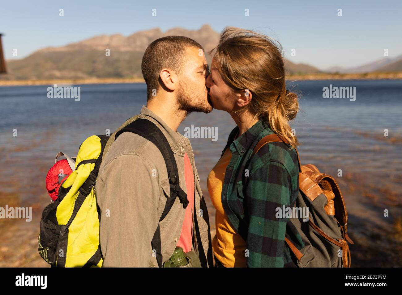 Seitenansicht des Paares, das vor einem See küsst Stockfoto