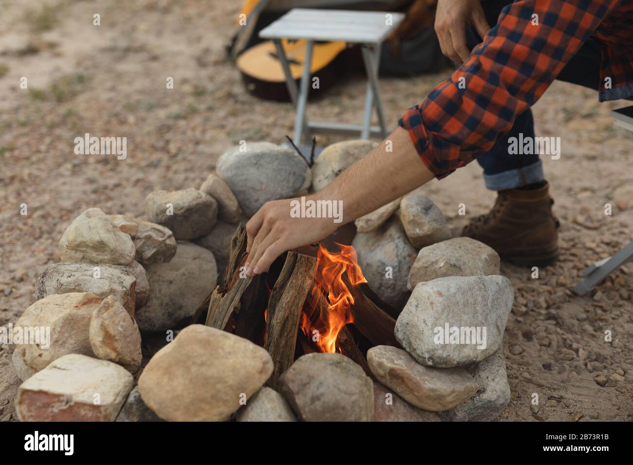 Seitenansicht des Menschen, der das Feuer des Lagers vorbereitet Stockfoto