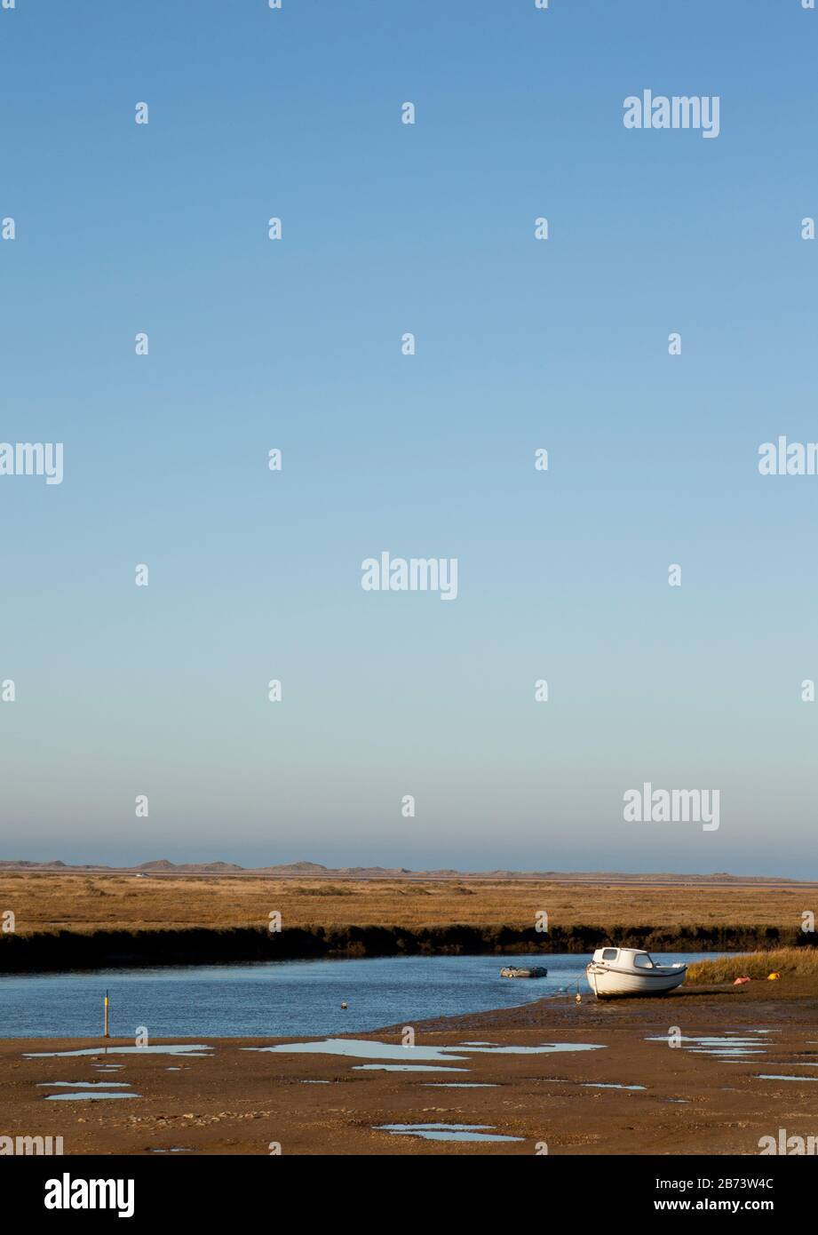 Ein weißes Boot, das bei Ebbe festgemacht wurde Stockfoto