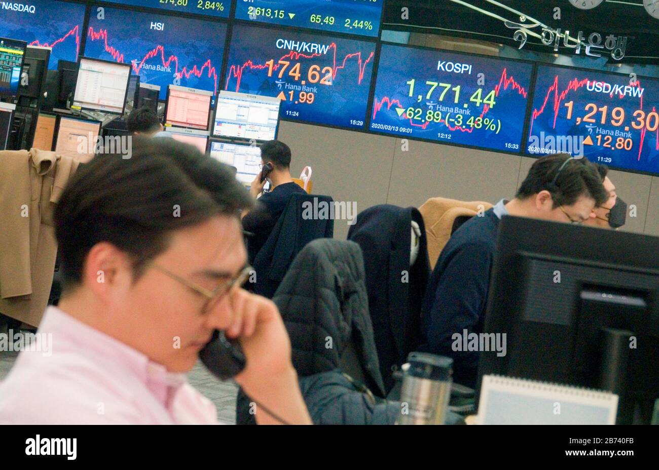 Korea Economy, 13. März 2020: Währungshändler arbeiten als Bildschirme zeigen Wechselkurse und KOSPI (Korea Composite Stock Price Index) (2. R) in einem Handelssaal der KEB Hana Bank in Seoul, Südkorea. Der KOSPI gab 62,89 Punkte oder 3,43 Prozent aus, um bei 1.771,44 zu schließen und der Koreaner gewann am Freitag bei einem sechsmonatigen Tiefpunkt gegenüber dem US-Dollar. Credit: Lee Jae-Won/AFLO/Alamy Live News Stockfoto