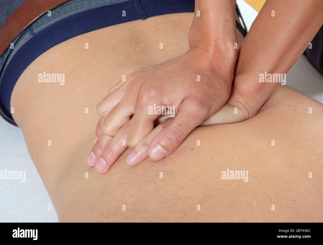 Ein Masseur massiert den Rücken und die unteren Körperteile des menschlichen Körpers, England. Stockfoto