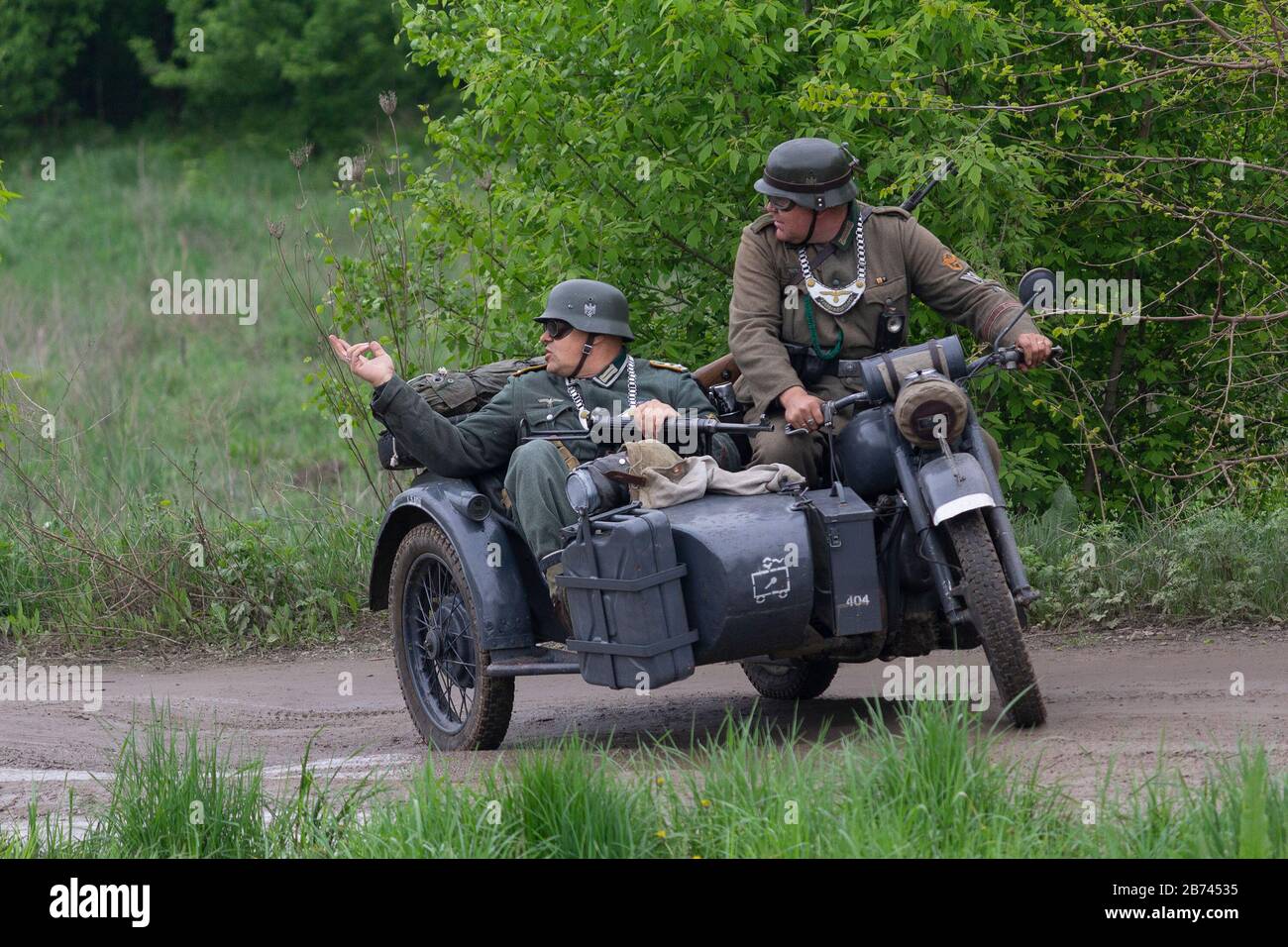 Kiew, Ukraine - 09. Mai 2019: Männer in der Kleidung deutscher Soldaten auf einem Motorrad beim historischen Umbau zum Jahrestag des Sieges i. Stockfoto