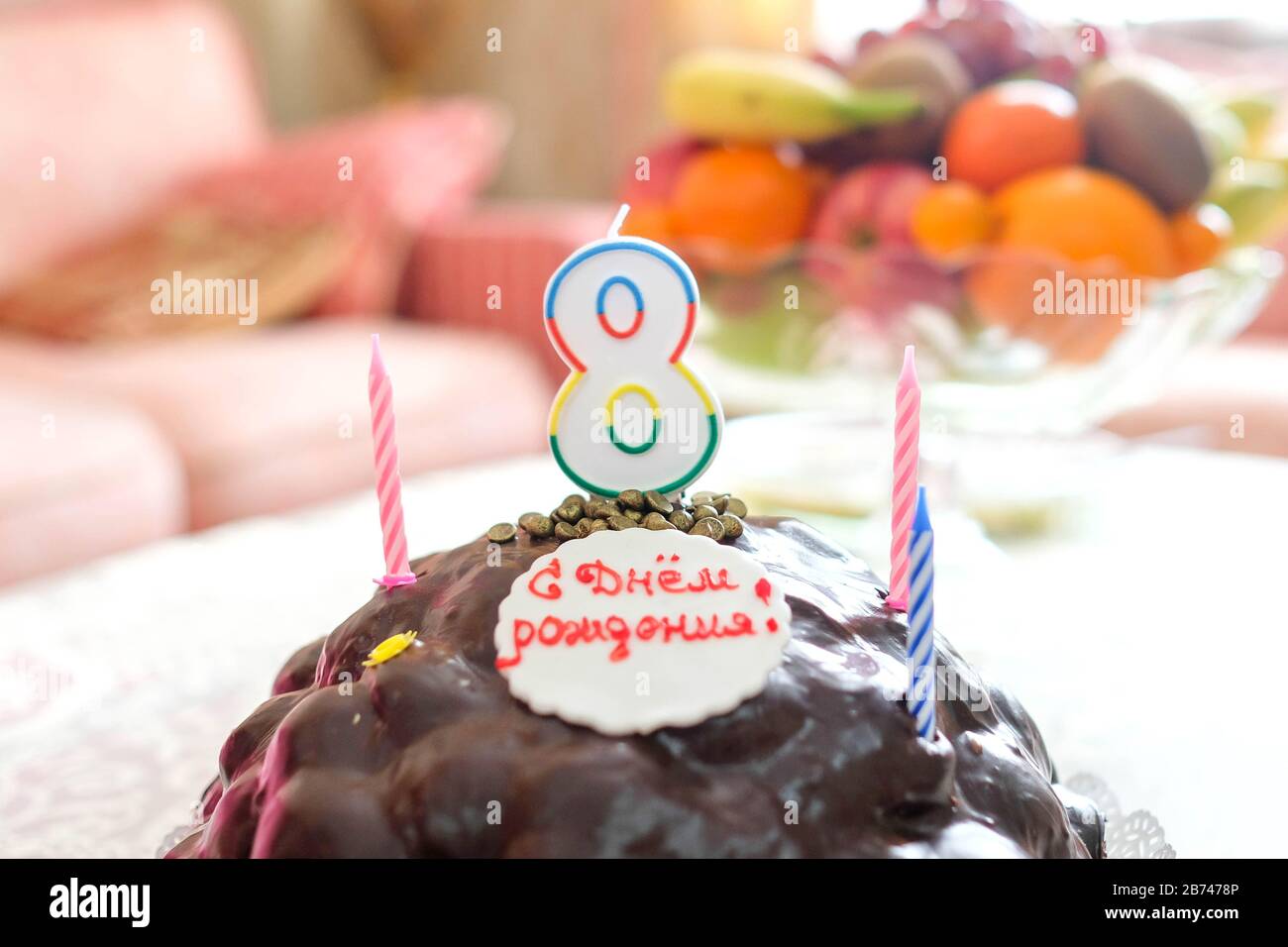 Weicher Fokus, verschwommener Hintergrund. Geburtstagskuchen mit Kerzen. Nummer 8. Stockfoto