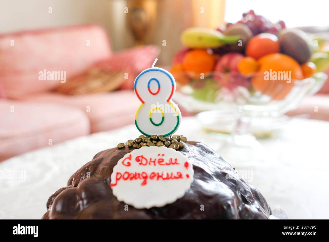 Weicher Fokus, verschwommener Hintergrund. Geburtstagskuchen mit Kerzen. Nummer 8. Worte: Alles gute zum Geburtstag! Stockfoto