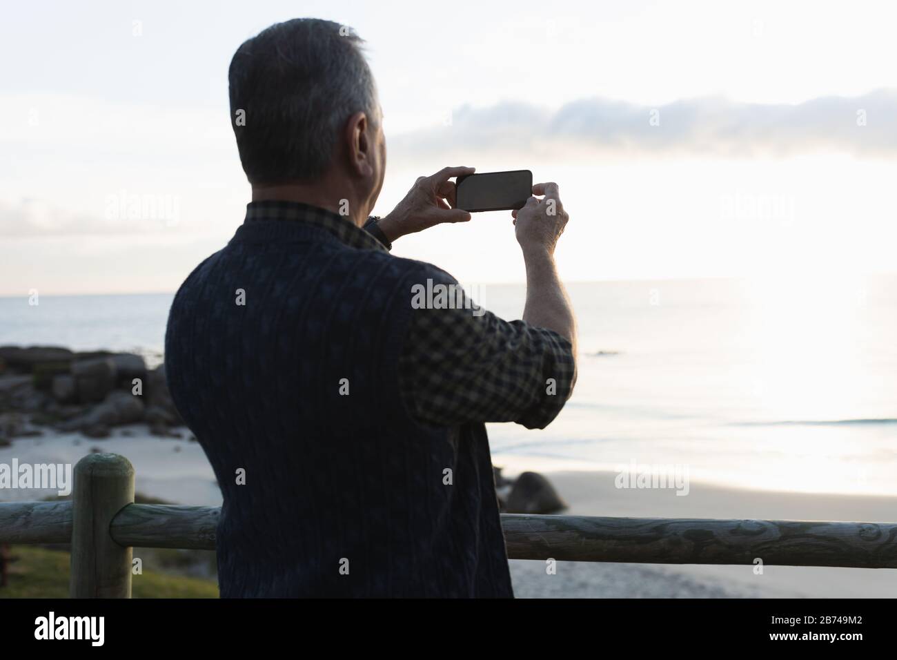 Leitender Mann fotografieren am Meer Stockfoto