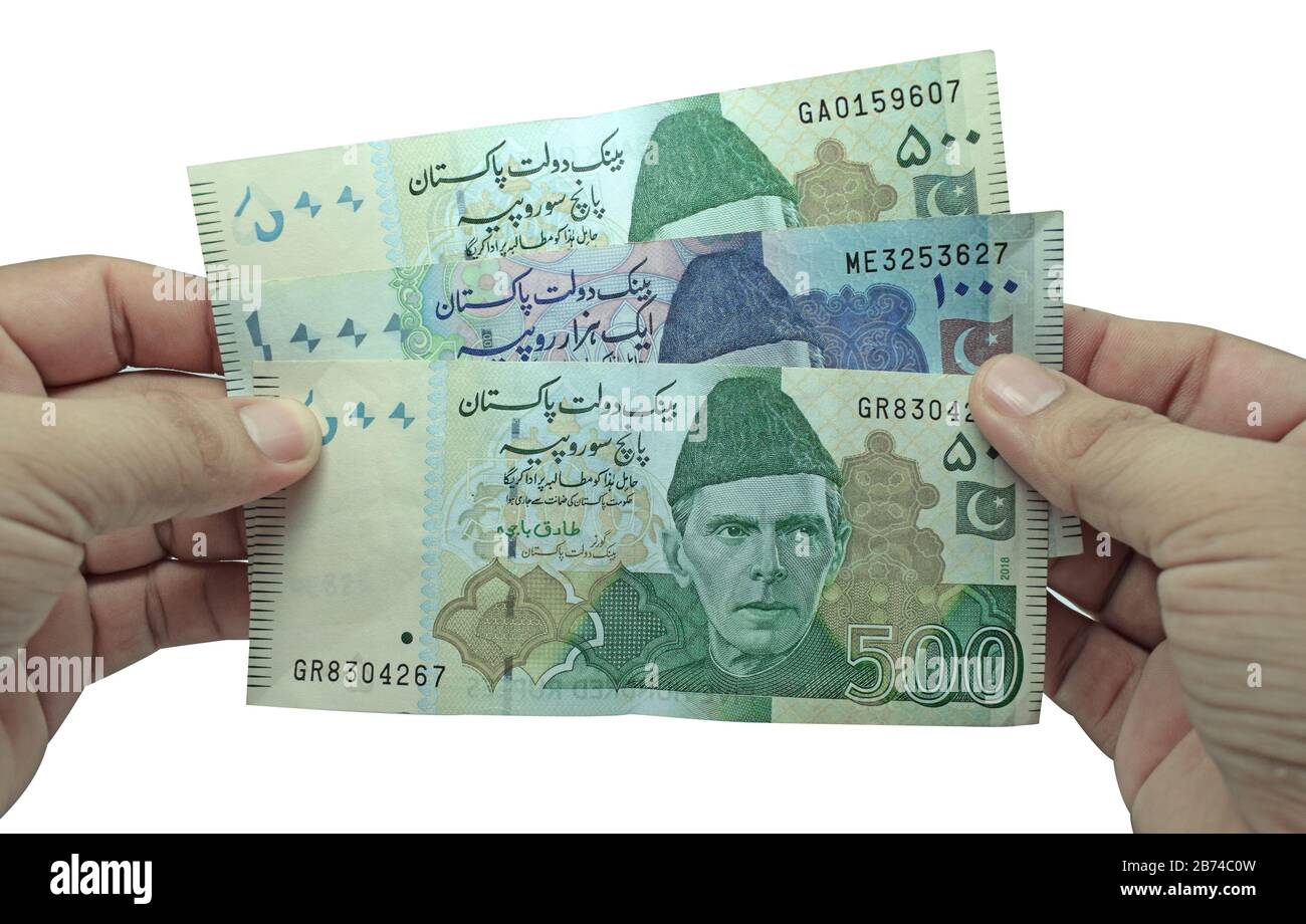 Brown man hält mehrere pakistanische Währungsscheine auf weißem Hintergrund Stockfoto