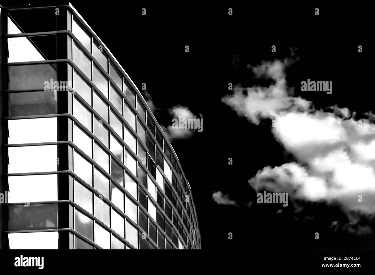 Himmel und Wolken reflektieren in Wolkenkratzeln. Gebäude von unten. Blsck und weißes Konzept Stockfoto