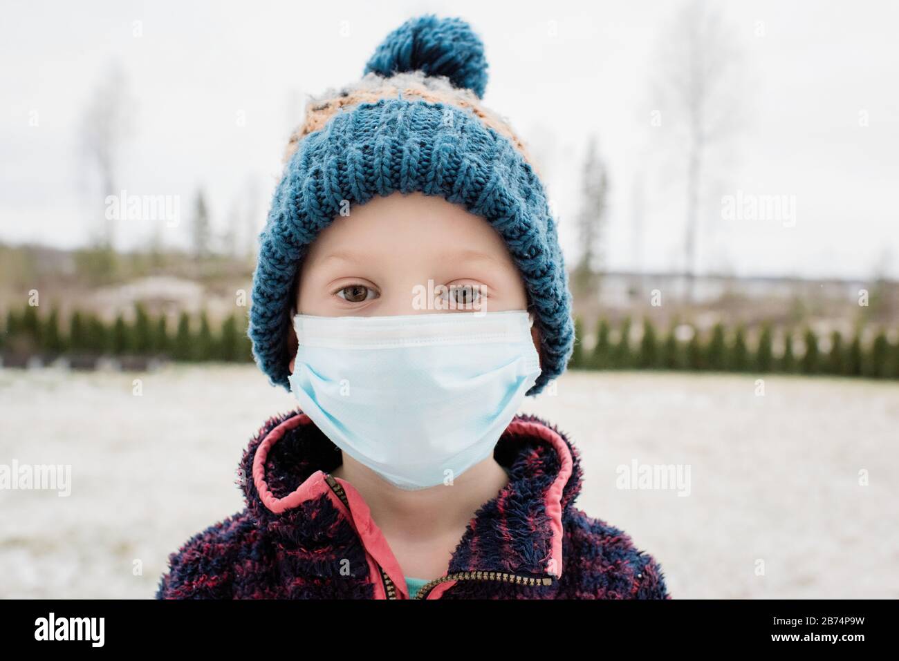 Kleiner Junge mit Gesichtsmaske auf sich vor Grippe und Virus zu schützen Stockfoto