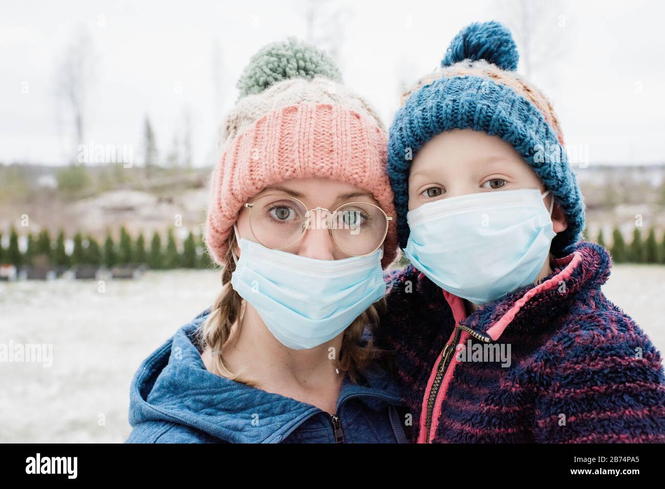 Mutter und Sohn tragen eine Gesichtsmaske als Schutz vor Virus und Grippe Stockfoto