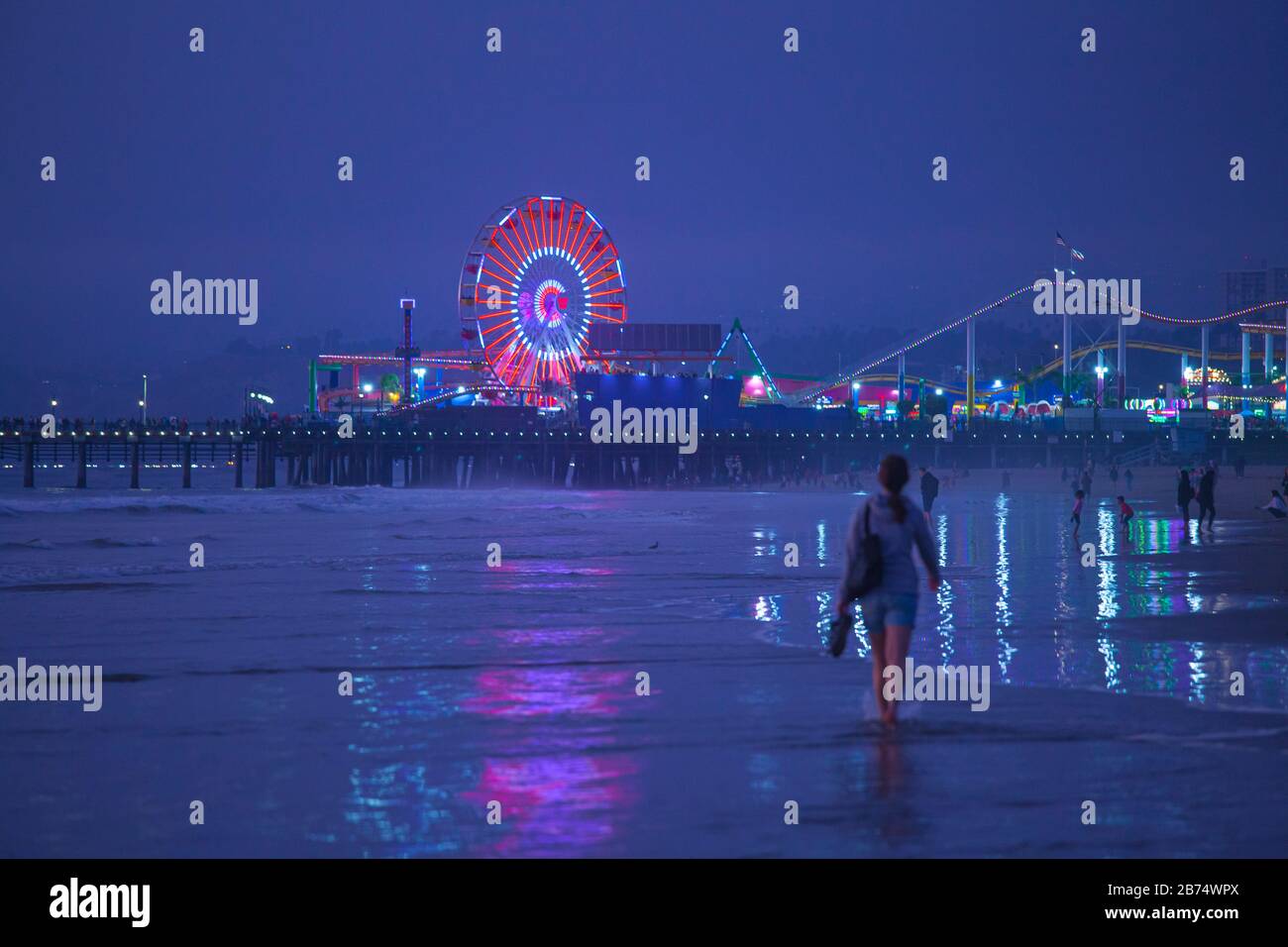 Frau, die am Santa Monica Beach, Santa Monica Pier, Kalifornien, USA spazieren geht Stockfoto