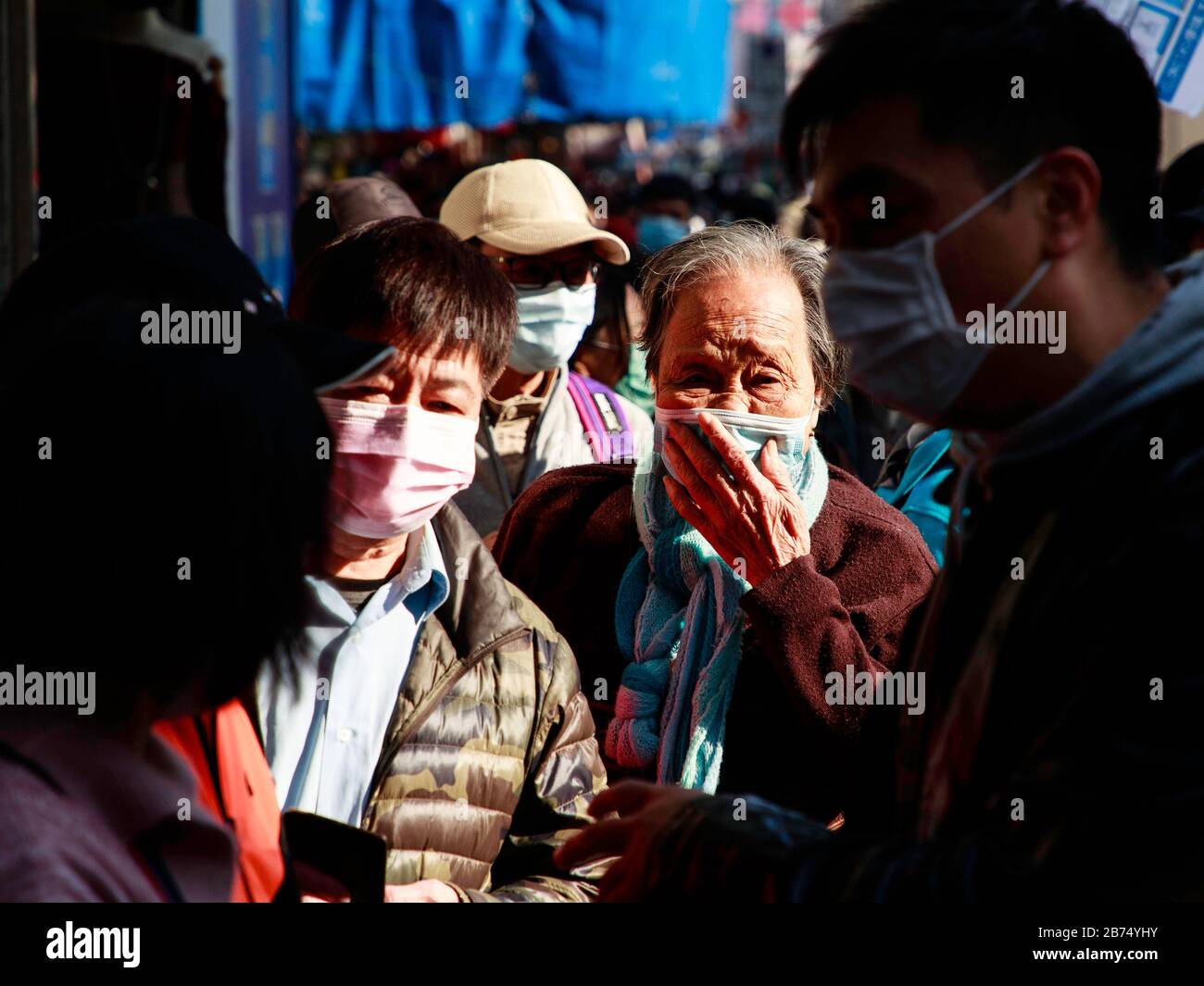 Senioren stellen sich kostenlos maskieren, die von einem Laden verteilt werden. In Hongkong mangelt es in der Stadt an chirurgischer Maske. Stockfoto
