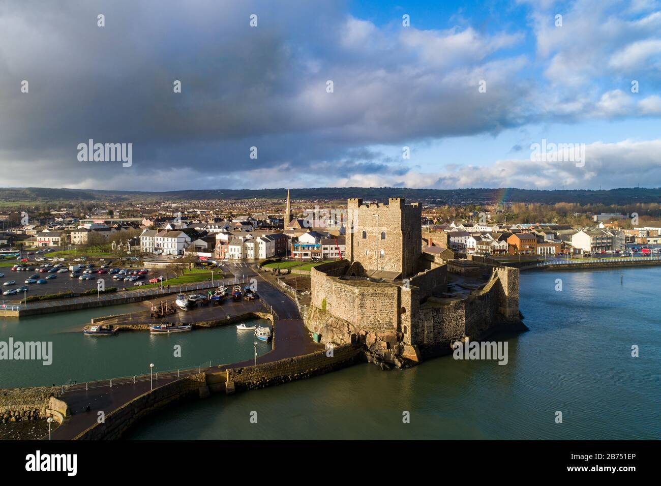 Mittelalterlichen normannischen Burg, Hafen mit Bootsrampe und Wellenbrecher in Carrickfergus bei Belfast, Nordirland, Großbritannien. Luftbild bei Sonnenuntergang in WIN Stockfoto