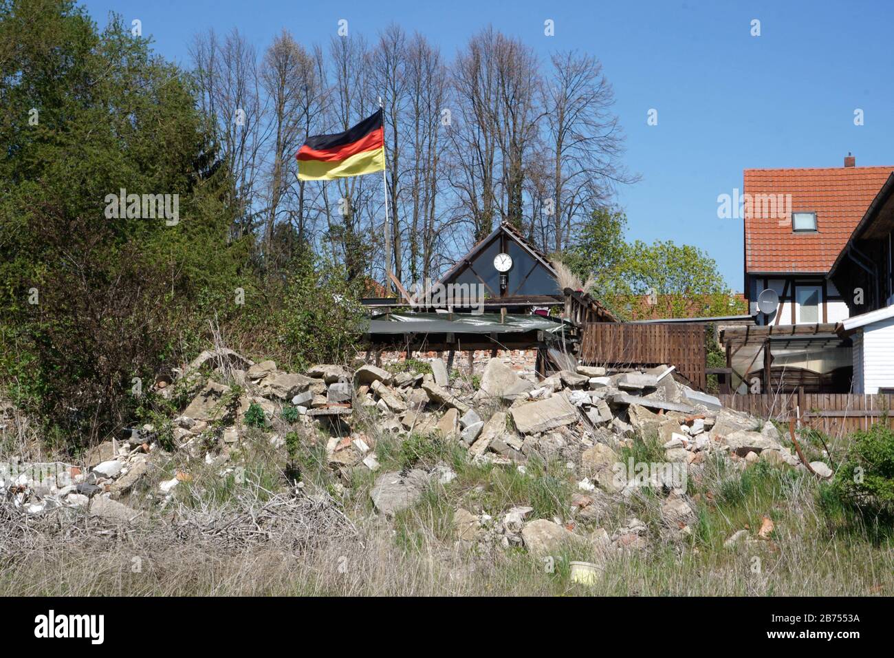 Eine deutsche Fahne flattert vor einem Trümmerberg auf einem Haus bei Schoeningen, Niedersachsen. [Automatisierte Übersetzung] Stockfoto