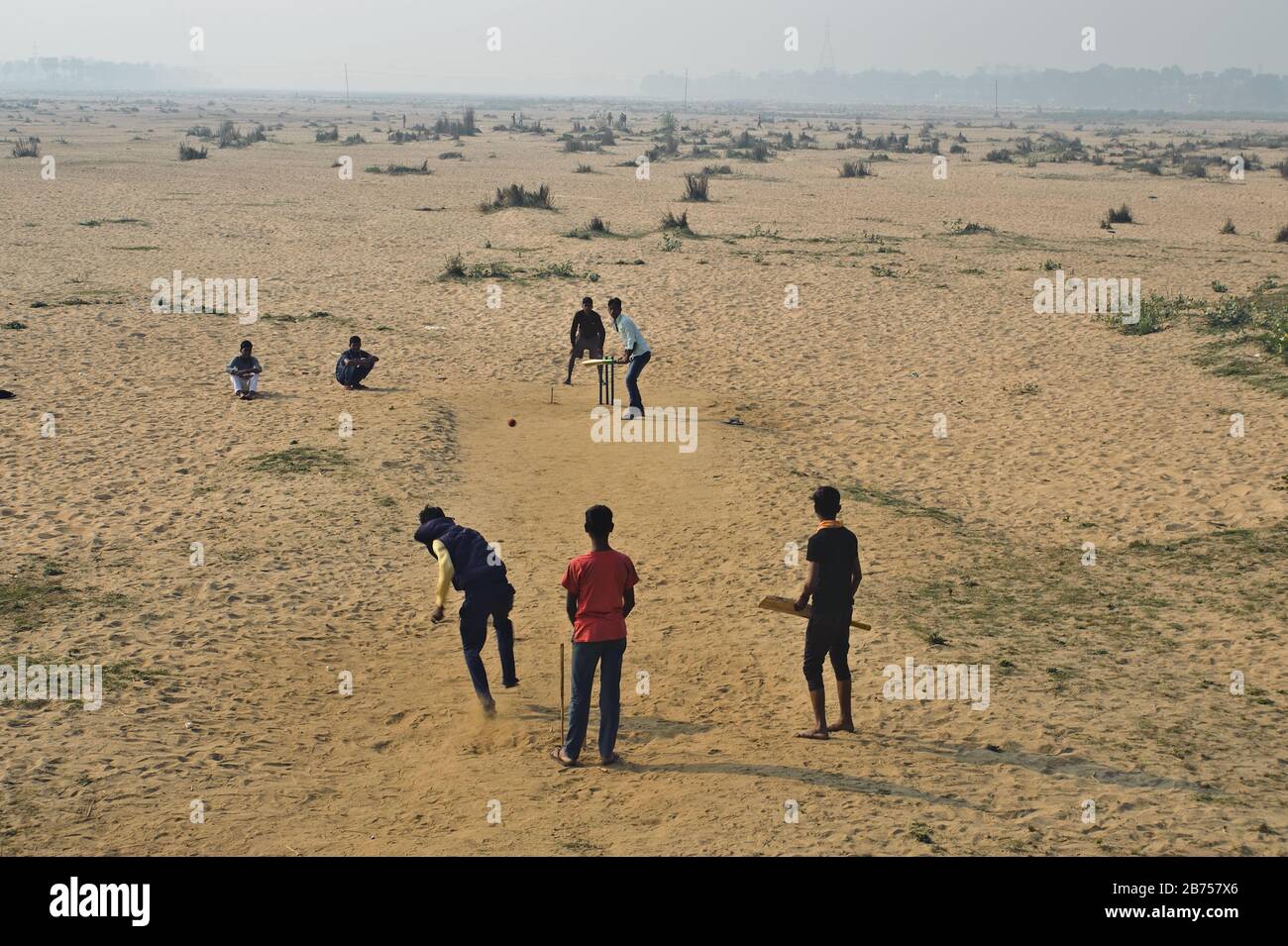 Teenager spielen Cricket in einem trockenen Flussbett (Indien) Stockfoto