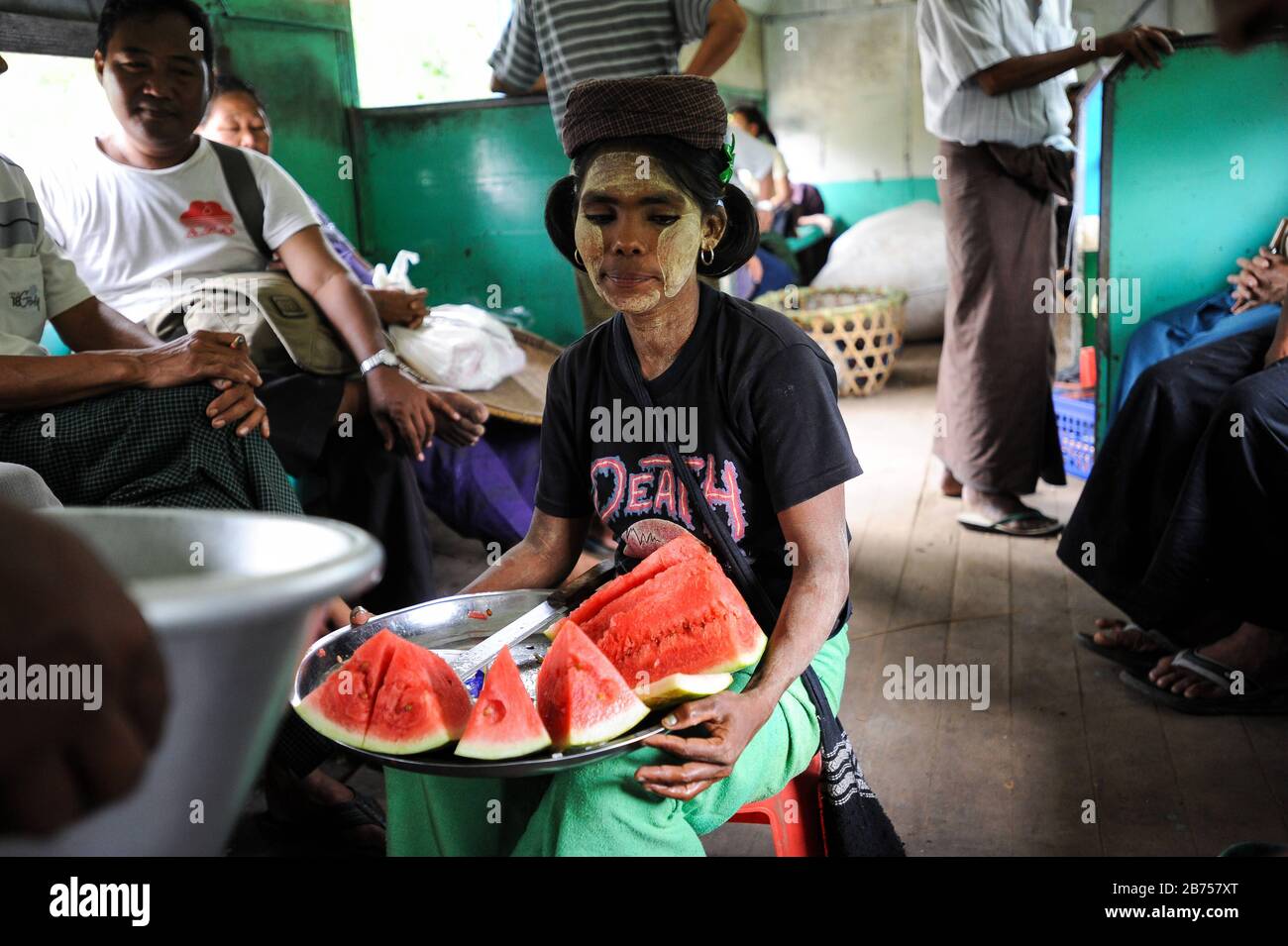 02.09.2013, Yangon, Republik der Union Myanmar, Asien - EINE Frau verkauft frische Wassermelonenscheiben in einem Zugfach der Ringbahn. Ihr Gesicht ist mit der typischen Thanaka-Paste verschmiert. Das lokale Vorortbahnnetz bedient den Großraum Yangon und wird von der Myanmar Railways betrieben. [Automatisierte Übersetzung] Stockfoto