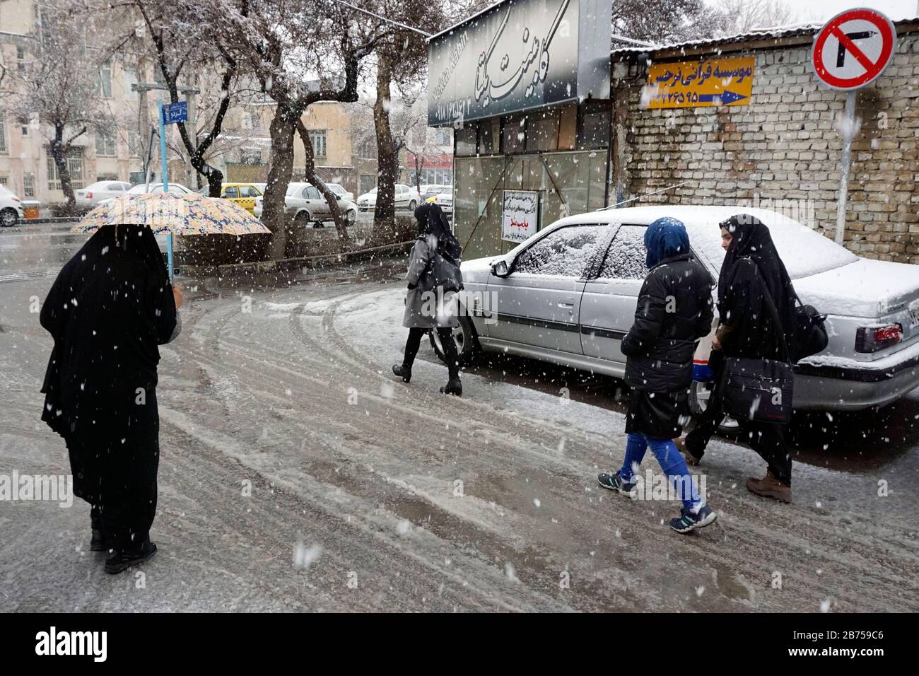 Starke Schneefälle in Arak, Iran, Frauen mit Chador und Regenschirm und traditioneller Kleidung am 16.03.2019. Nachdem sich die USA aus dem internationalen Atomabkommen zurückgezogen haben, verhängt das Land erneut Sanktionen gegen den Iran. [Automatisierte Übersetzung] Stockfoto