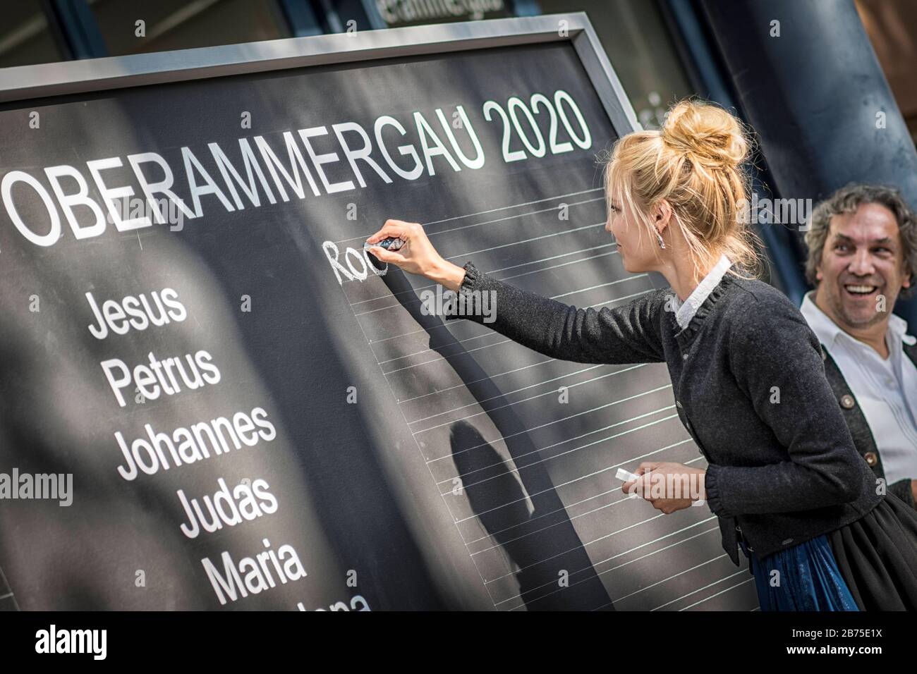 Lena Rödl schreibt auf der Tafel die Namen der Hauptdarstellerinnen der Oberammergauer Passionsspiele 2020, im Hintergrund Spieldirektor Christian Stückl. [Automatisierte Übersetzung] Stockfoto