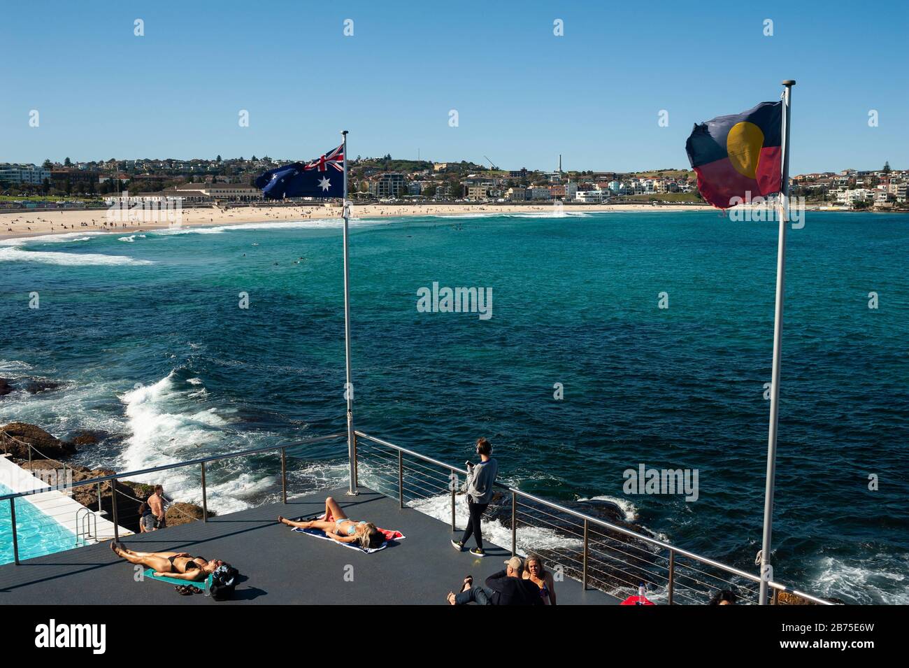 21.09.2018, Sydney, New South Wales, Australien - die Menschen sonnen sich auf der Sonnenterasse des Bondi Iceberg Schwimmvereins, während der Strand von Bondi Beach im Hintergrund zu sehen ist. [Automatisierte Übersetzung] Stockfoto