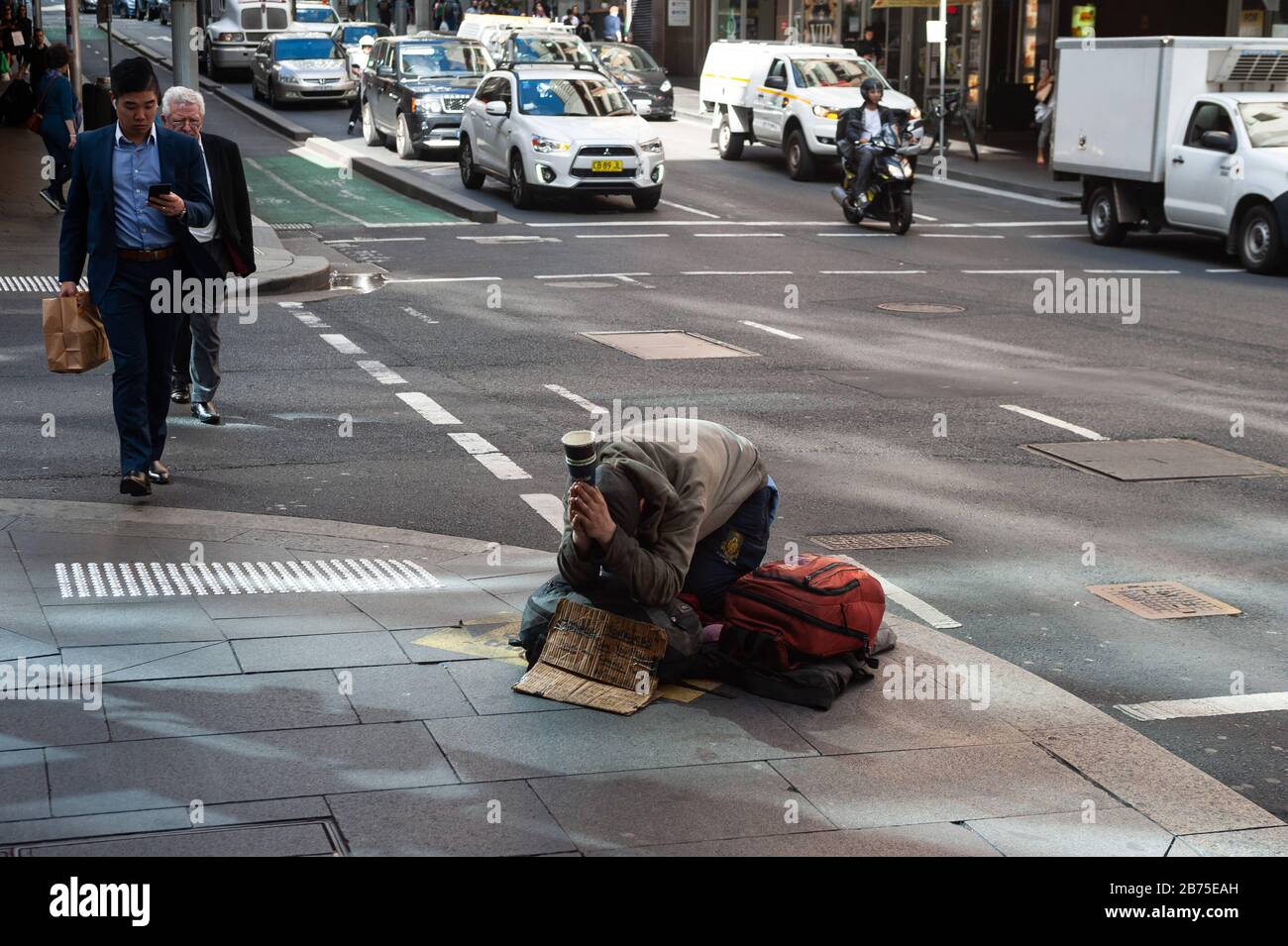 19.09.2018, Sydney, New South Wales, Australien - EIN Obdachloser kniet auf einem Gehweg in der Innenstadt von Sydney und bittet um eine Geldspende. [Automatisierte Übersetzung] Stockfoto