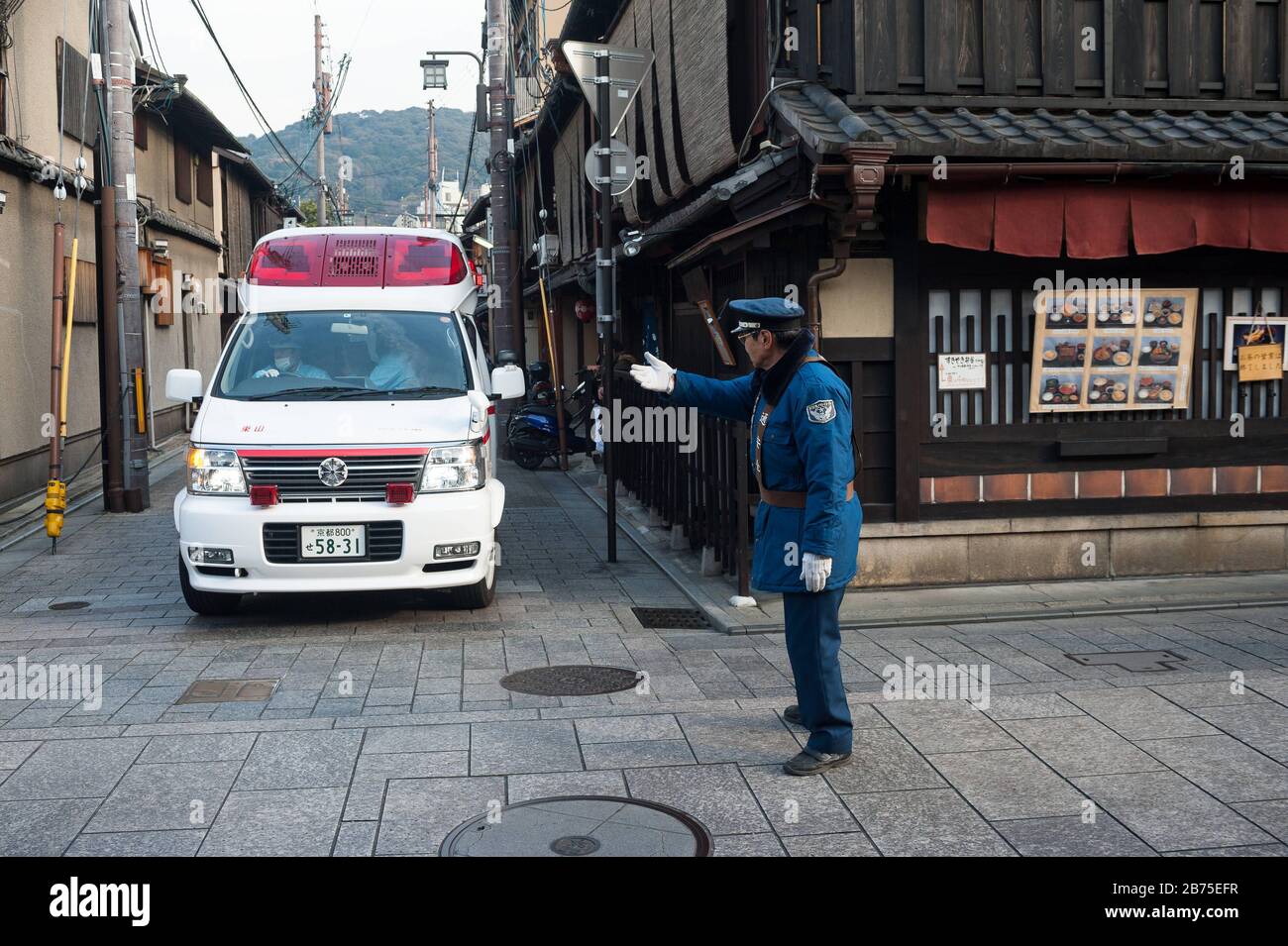 23.12.2017, Kyoto, Japan, Asien - EINE Verkehrsaufsicht regelt den Verkehr an einer Kreuzung in der Altstadt von Kyoto. [Automatisierte Übersetzung] Stockfoto