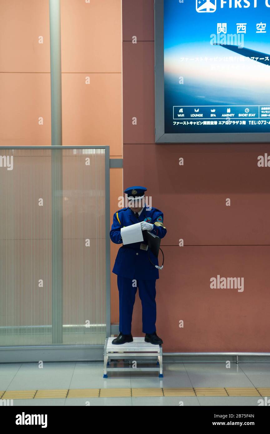 23.12.2017, Osaka, Japan, Asien - EIN uniformierter Flughafenmitarbeiter steht auf einer kleinen Plattform am Kansai International Airport und macht sich Notizen. [Automatisierte Übersetzung] Stockfoto