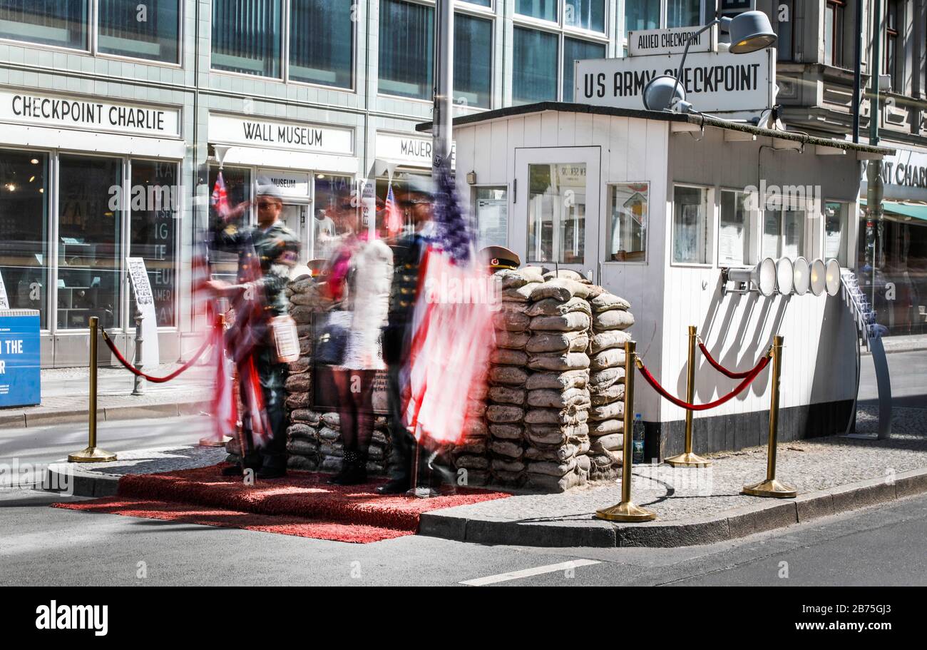 Eine lange Exposition zeigt einen Touristen, der am 04.05.2018 neben zwei Männern in amerikanischen Militäruniformen am Checkpoint Charlie ihr Bild machen lässt. [Automatisierte Übersetzung] Stockfoto