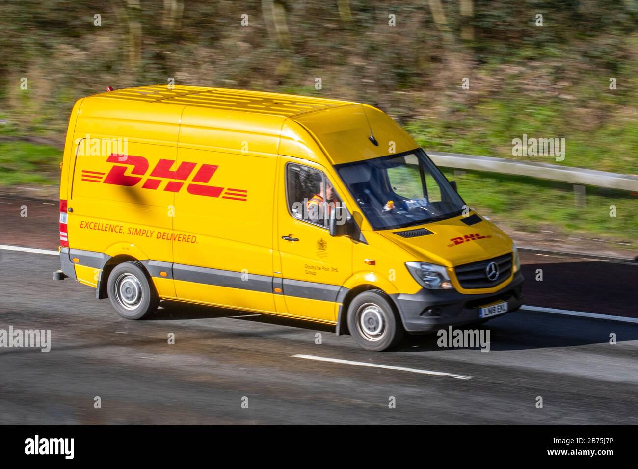 DHL-Liefermann fährt mit dem gelben Mercedes Sprinter M6, Lancaster, Großbritannien; Fahrzeugverkehr, Transport, moderne, nordwärts gerichtete Straße auf der dreispurigen Autobahn. Stockfoto