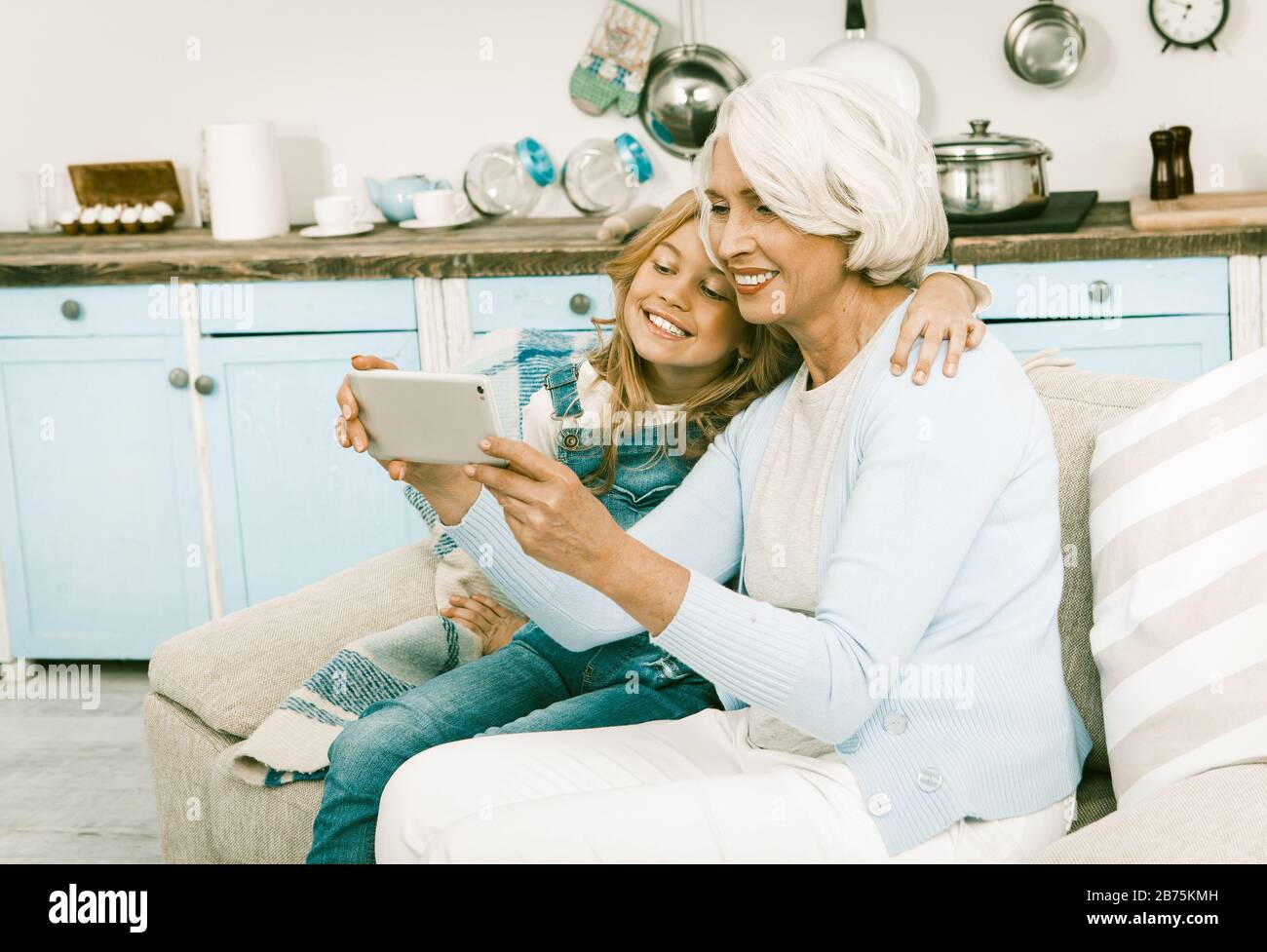 Senior Und New Generation Entscheiden Sich Für New Technologies Oma Und Enkelin Machen Selbstfotos, Selfies On Smart Phone, Während Sie Auf Sofa In Ho Sitzen Stockfoto