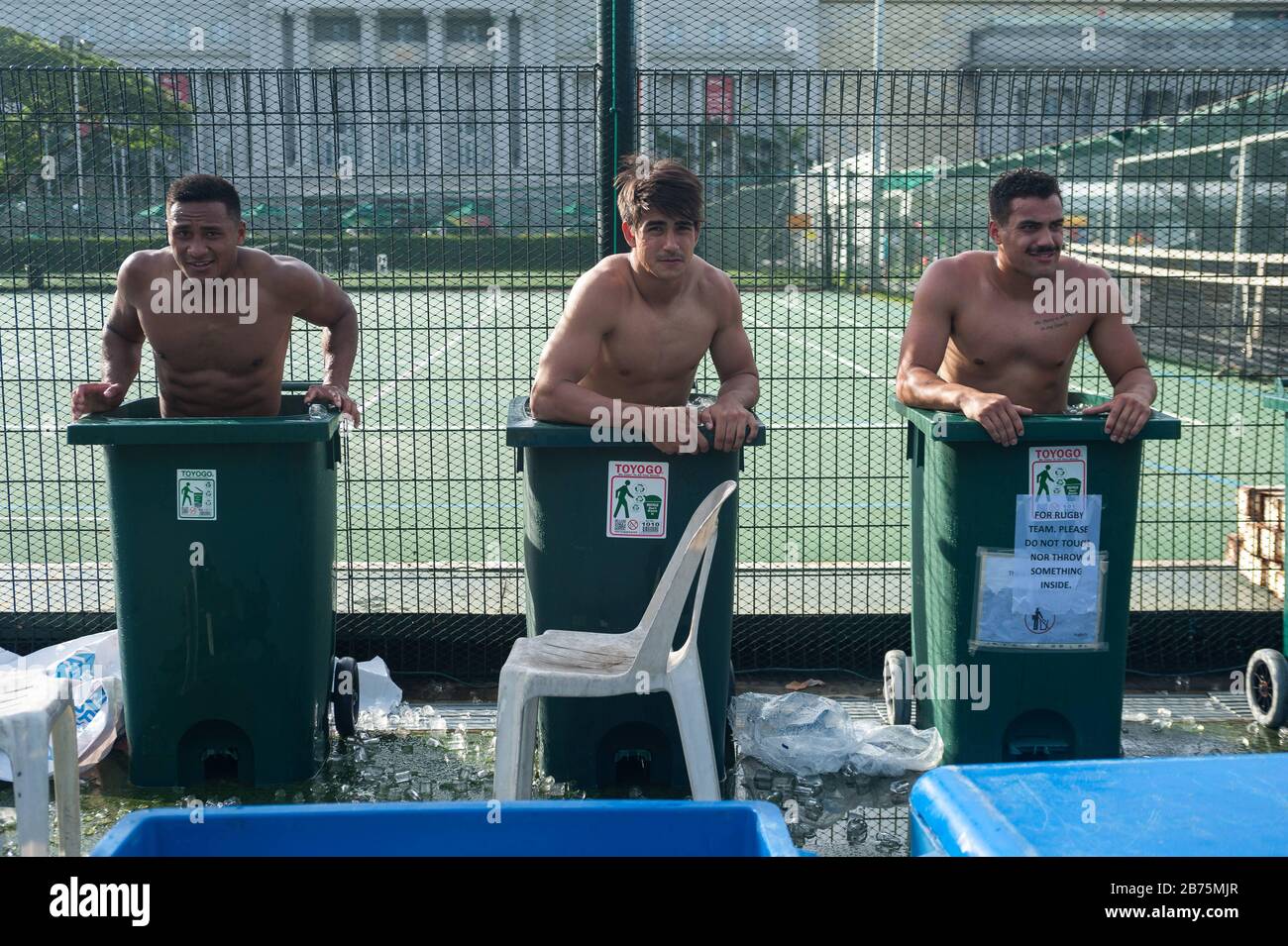 04.11.2017, Singapur, Republik Singapur, Asien - nach einem Spiel beim Rugby Sevens Tournament kühlen drei Spieler des australischen Rugbyteams Casuarina Cougars in Mülltonnen ab, die mit Eiswasser gefüllt sind. Nur für redaktionelle Zwecke [automatisierte Übersetzung] Stockfoto