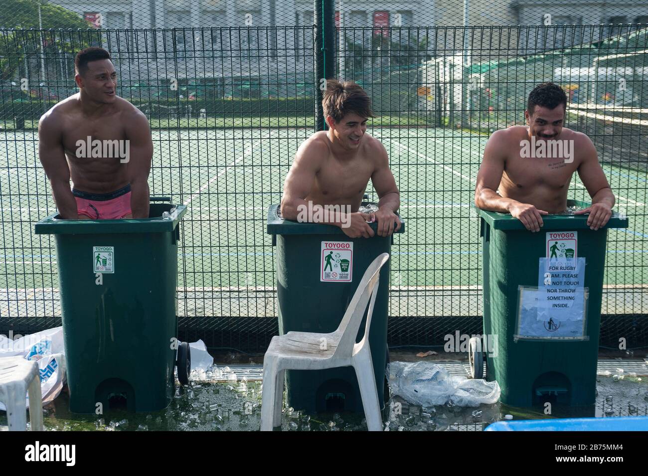 04.11.2017, Singapur, Republik Singapur, Asien - nach einem Spiel beim Rugby Sevens Tournament kühlen drei Spieler des australischen Rugbyteams Casuarina Cougars in Mülltonnen ab, die mit Eiswasser gefüllt sind. Nur für redaktionelle Zwecke [automatisierte Übersetzung] Stockfoto