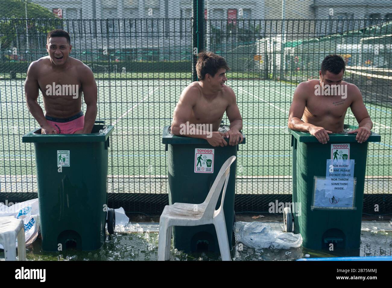 04.11.2017, Singapur, Republik Singapur, Asien - nach einem Spiel beim Rugby Sevens Tournament kühlen drei Spieler des australischen Rugbyteams Casuarina Cougars in Mülltonnen ab, die mit Eiswasser gefüllt sind. Nur für redaktionelle Zwecke [automatisierte Übersetzung] Stockfoto