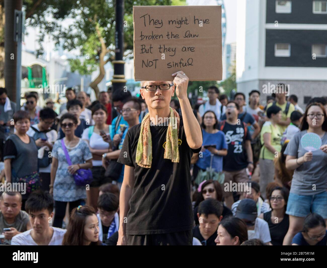 Ein Protestler hält ein Plakat, um gegen die Inhaftierung der letzten 16 pro-demokratischen Aktivisten zu protestieren, darunter Nathan Law, Joshua Wong und Alex Chow in Hongkong. Law, Wong und Chow wurden inhaftiert, weil sie die Verbindung zwischen der Regierung und dem Hauptsitz in Hongkong stürmen, die die 79-tägige Bewegung Occupy Central auslöste. Der Regierung wird vorgeworfen, mit rechtlichen Mitteln die Demokratisierung in Hongkong zu unterdrücken. Stockfoto