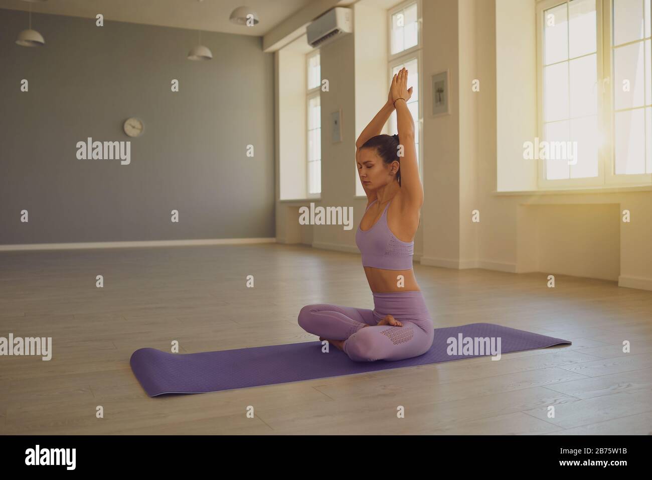 Junge Frau, die Yoga macht. Meditierende athletische Frau, die Yoga macht, entspannen konzentrierte Balance im Raum. Stockfoto