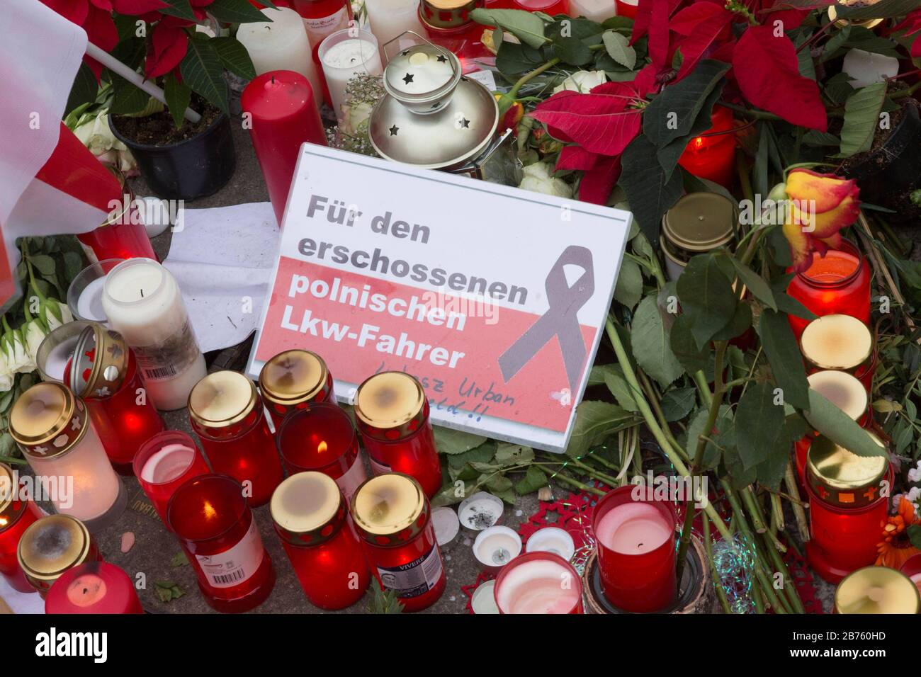 Ein Schild mit der Aufschrift "für den erschossenen polnischen Autofahrer" liegt inmitten von Kerzen und Blumen an der Stelle, an der am 19.12.16 nach einem Terro-Angriff mit einem Lastwagen 12 Menschen starben. Der Weihnachtsmarkt wurde wieder eröffnet, 23.12.2016 [automatisierte Übersetzung] Stockfoto