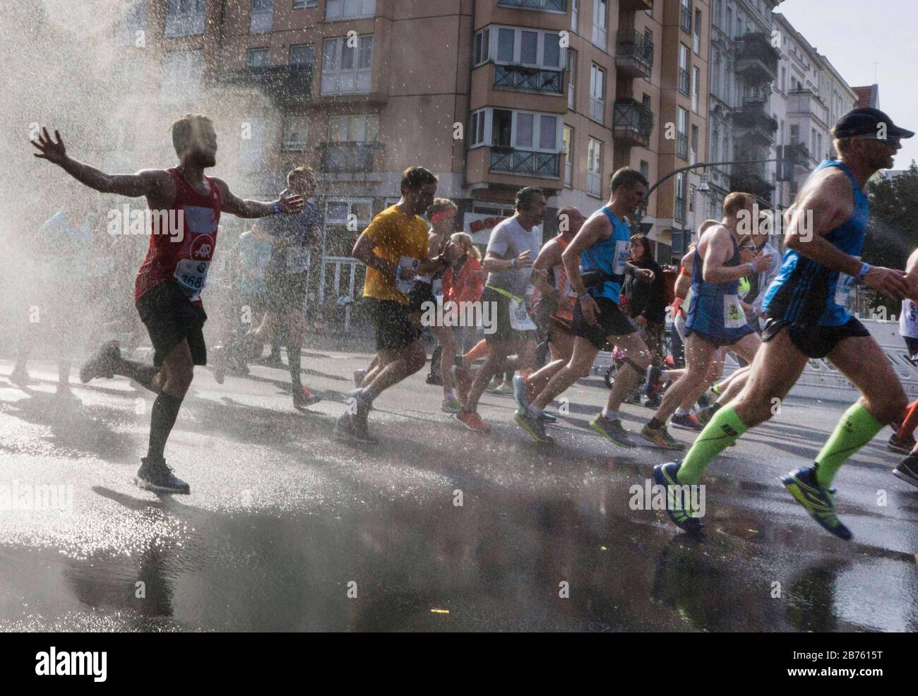 Die Teilnehmer des 43. Berlin-Marathons im Berliner Schöneberger Kreis werden mit einer Wasserdusche abgekühlt. 41.283 Läufer nahmen am Marathon Teil. [Automatisierte Übersetzung] Stockfoto