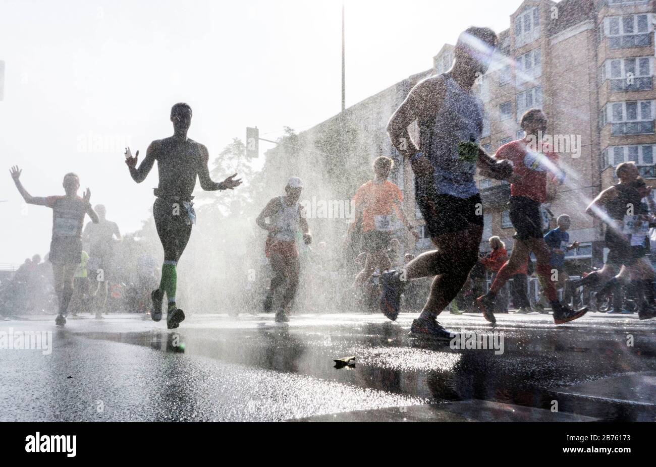 Die Teilnehmer des 43. Berlin-Marathons im Berliner Schöneberger Kreis werden mit einer Wasserdusche abgekühlt. 41.283 Läufer nahmen am Marathon Teil. [Automatisierte Übersetzung] Stockfoto