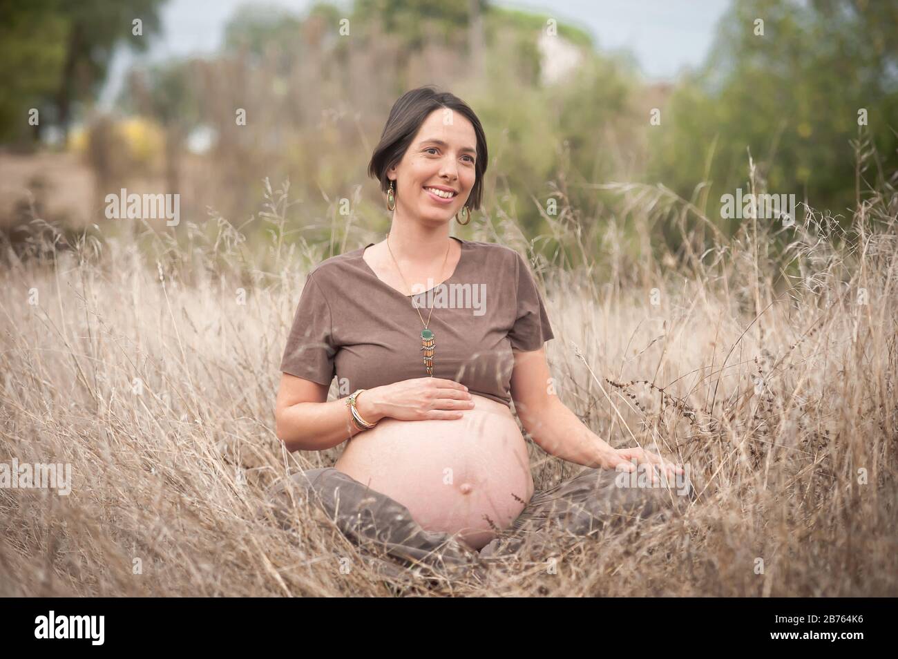 Süß glücklich schwanger auf den Feldern Stockfoto