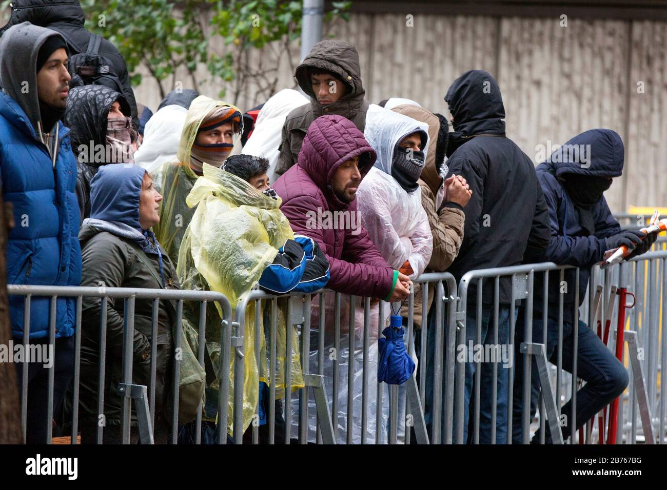 Asylsuchende Flüchtlinge werden am 15. Oktober 2015 im Berliner Landesamt für Gesundheit und Soziales, LaGeSo, auf ihre Registrierung bei kaltem und nassem Wetter warten. Mit Decken und einfacher Regenkleidung versuchen die Flüchtlinge sich vor Regen und Kälte zu schützen. [Automatisierte Übersetzung] Stockfoto