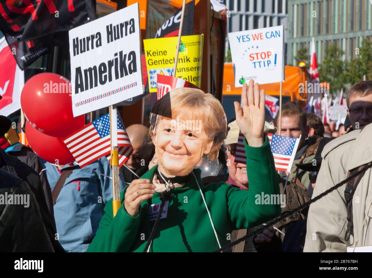 Ein Demonstrant trägt bei einer Demonstration in Berlin eine Angela Merkel-Maske, um gegen das Freihandelsabkommen TTIP zu protestieren. [Automatisierte Übersetzung] Stockfoto