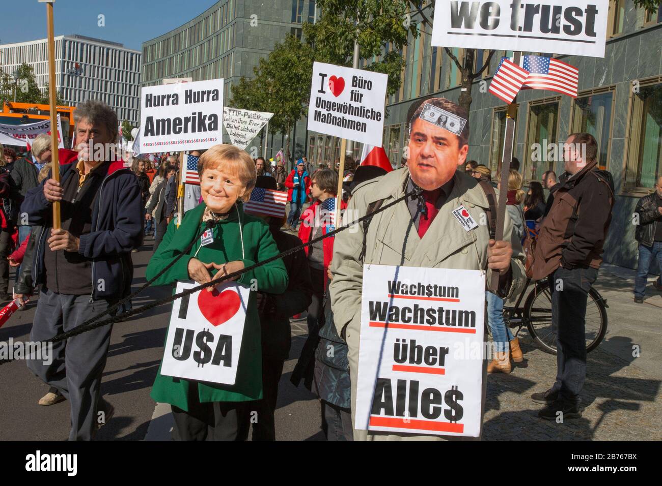 Demonstrationen tragen Masken von Angela Merkel und Sigmar Gabriel bei einer Demonstration in Berlin, um gegen das Freihandelsabkommen TTIP zu protestieren. [Automatisierte Übersetzung] Stockfoto