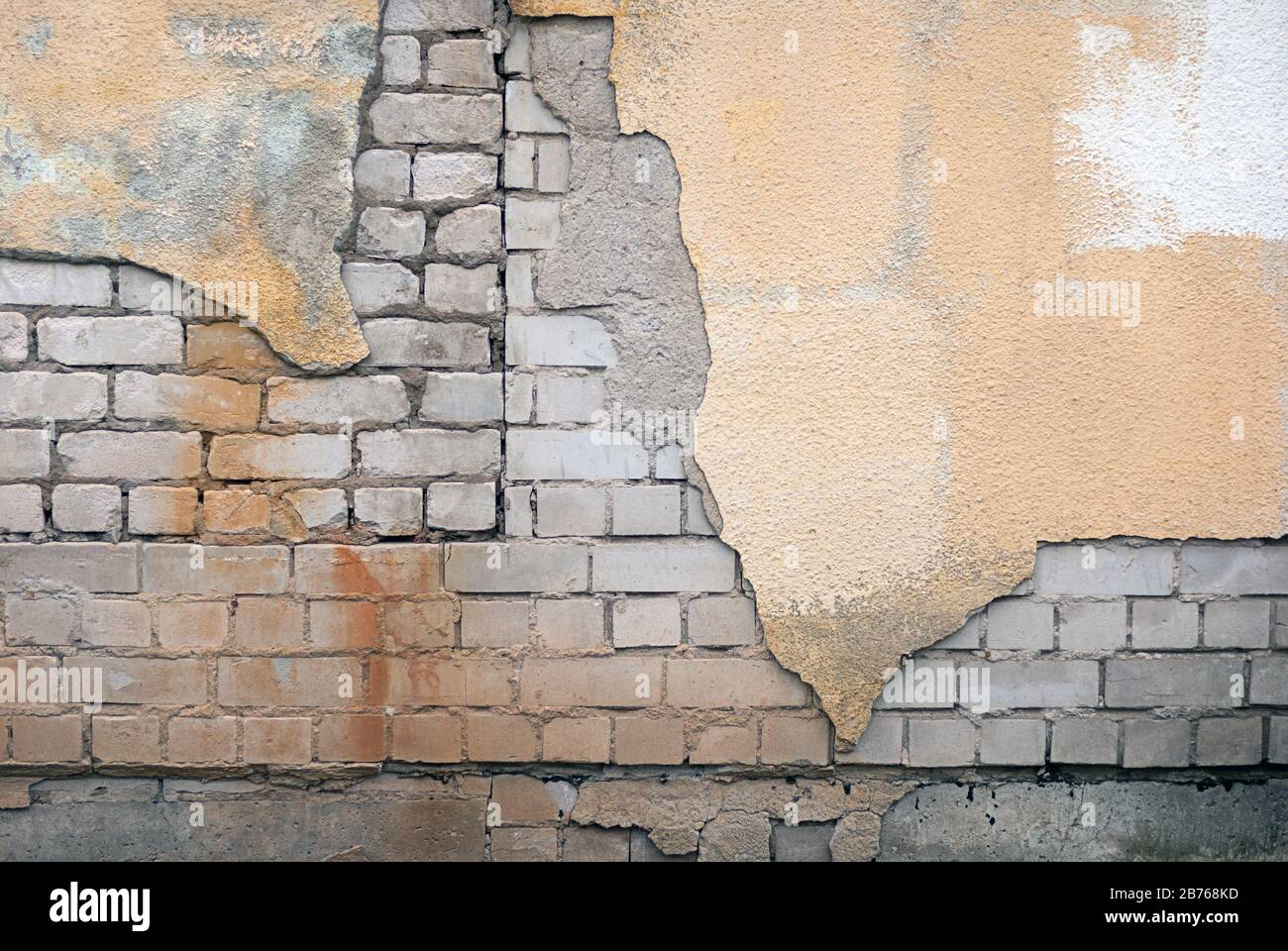 Zerstörte Ziegelwand mit Stuck und Rost Stockfoto